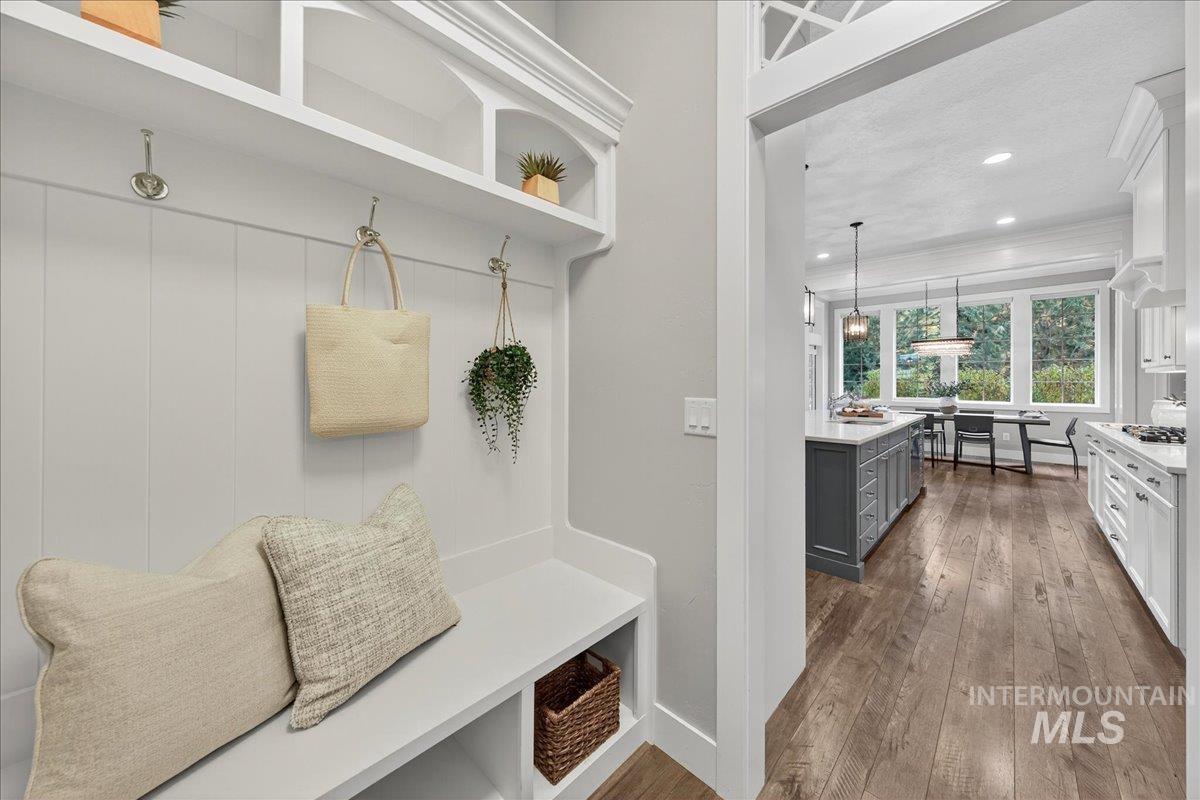 Mudroom with dark wood-style floors, crown molding, and recessed lighting