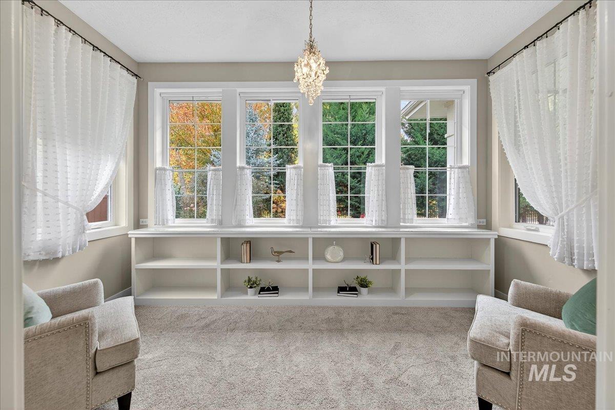 Living area with light colored carpet and a chandelier