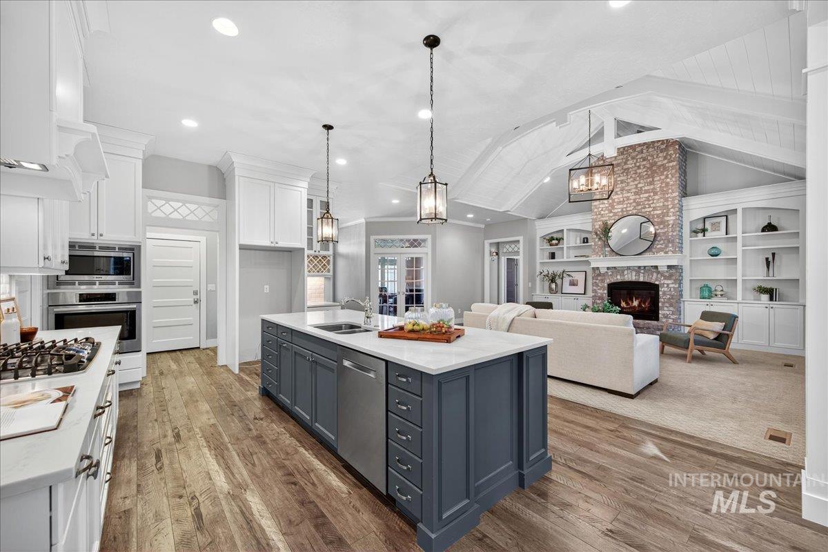 Kitchen with a chandelier, white cabinetry, a fireplace, decorative light fixtures, and dark wood-style floors