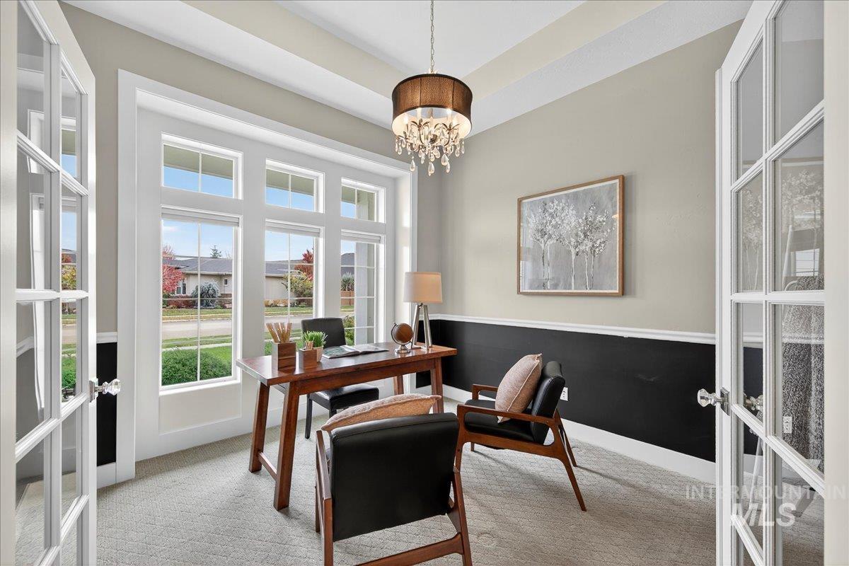 Office area featuring french doors, light carpet, and a chandelier