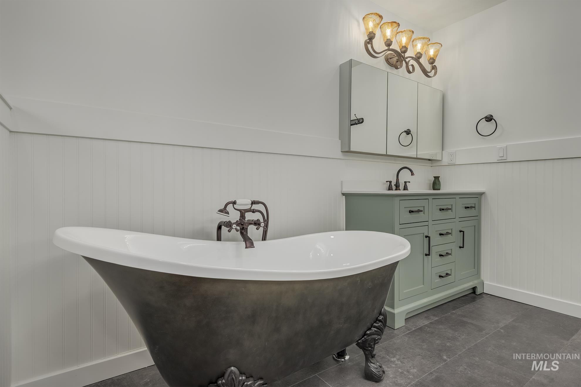 Freestanding soaking tub with ornate feet and exposed plumbing