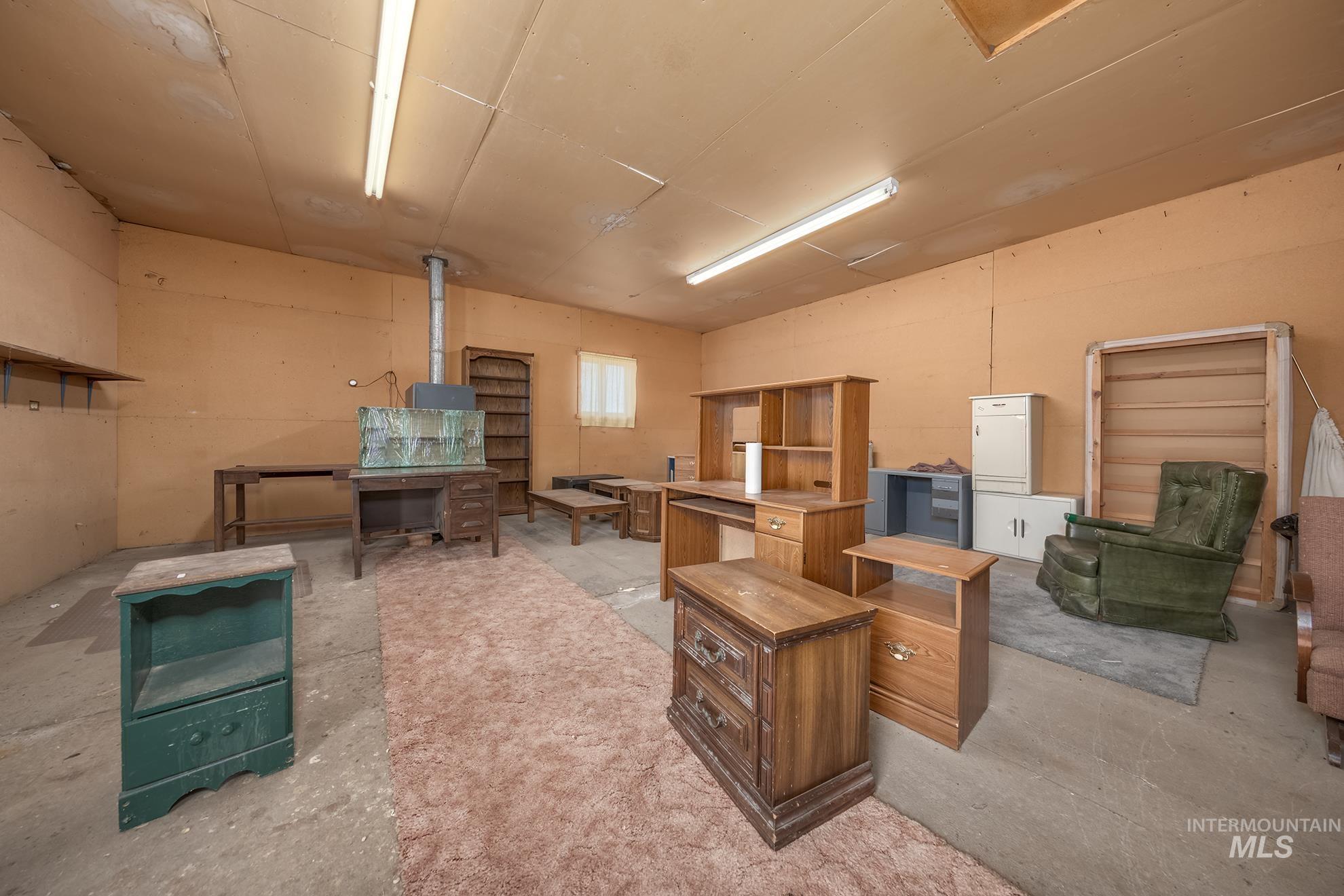 Spacious interior room featuring concrete flooring and light orange walls