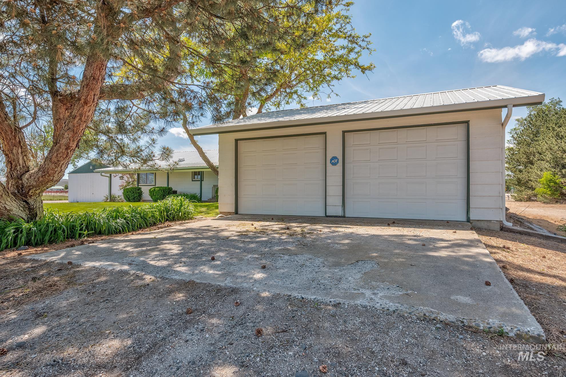 Detached two-car garage with white panel doors and a white metal roof