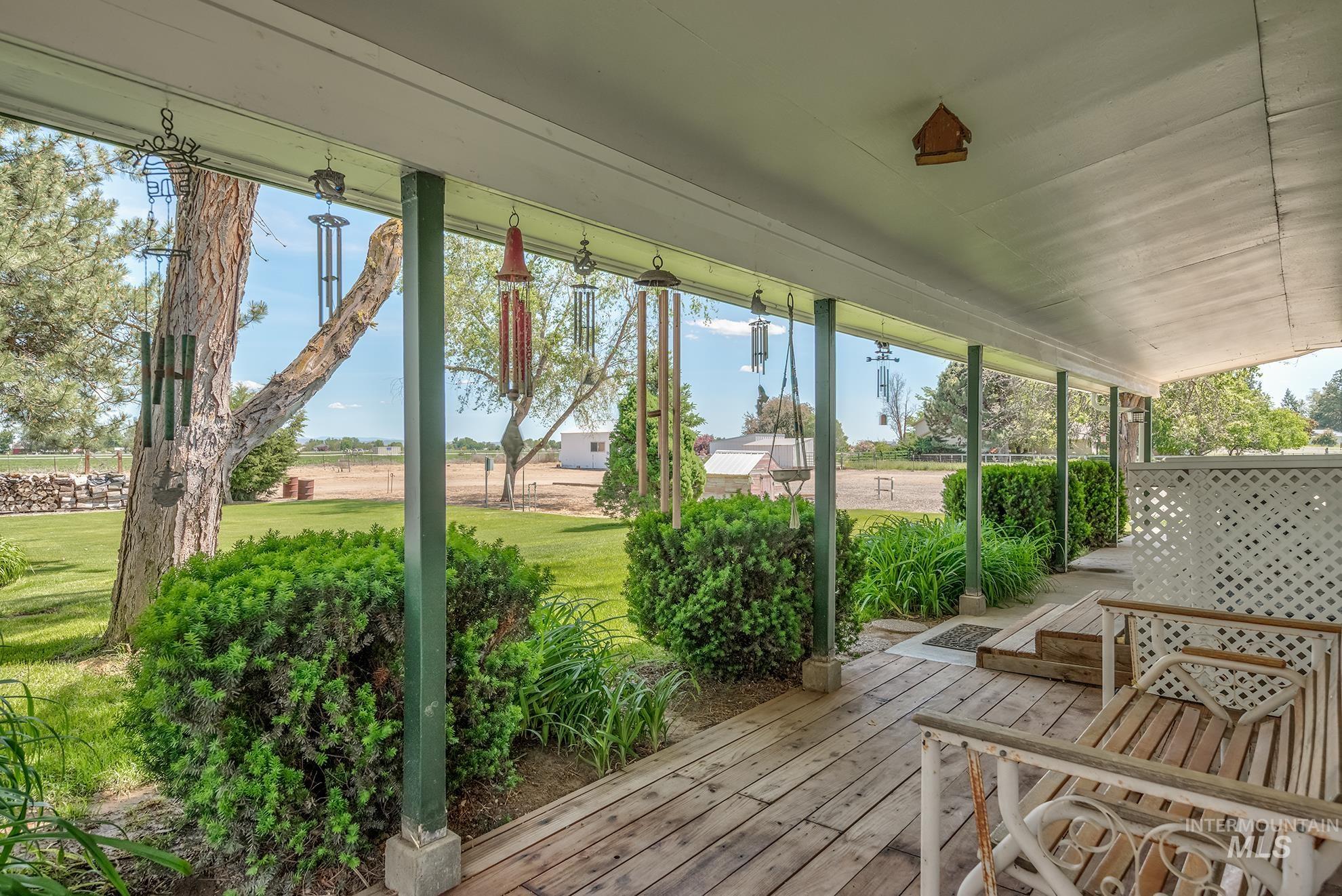 Expansive covered porch featuring a wood-finish floor, white lattice railing, and multiple support pillars