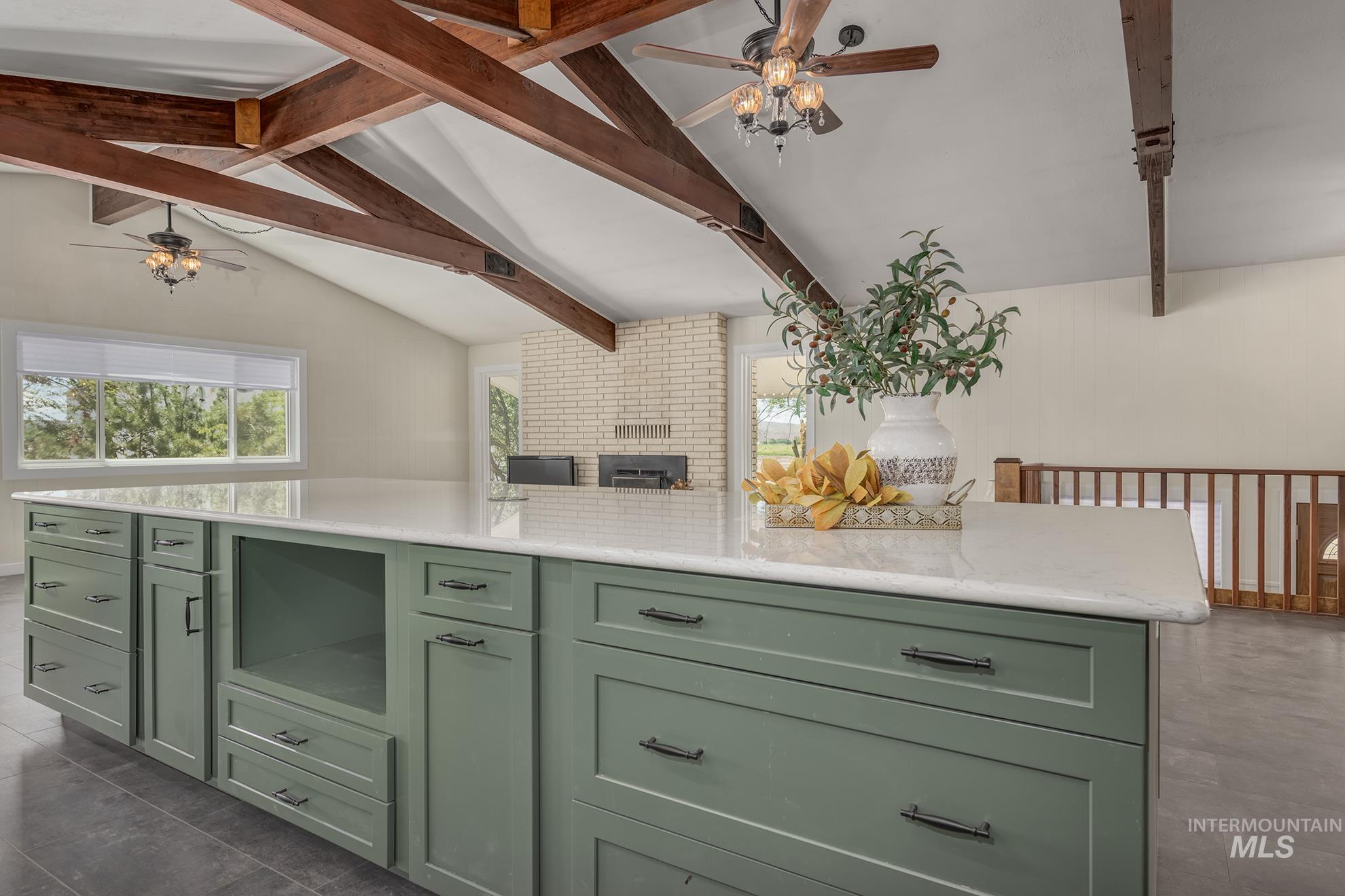Kitchen island featuring a light-toned countertop and green cabinetry