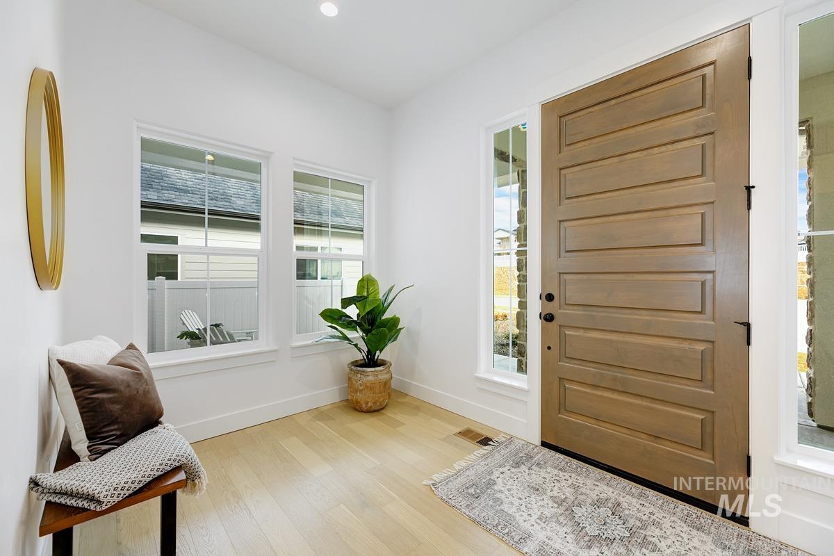 Foyer entrance with light wood finished floors and recessed lighting