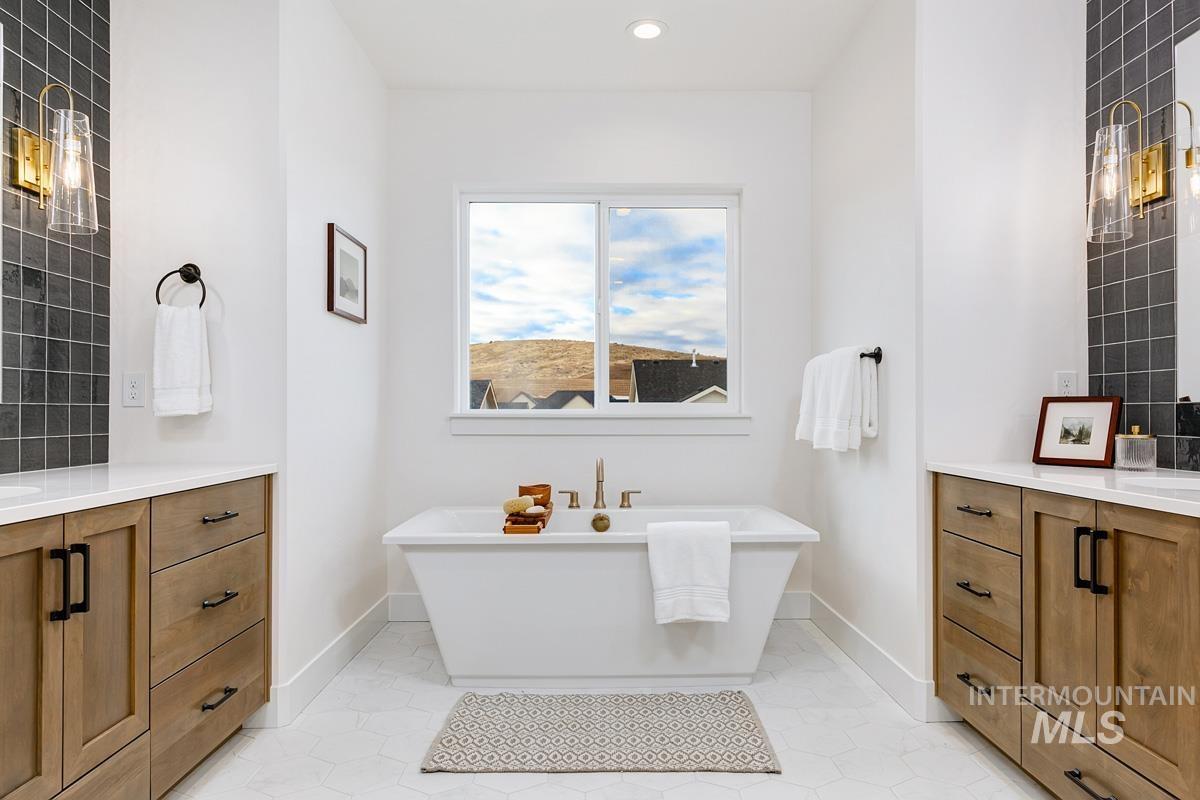Bathroom featuring vanity, a soaking tub, light tile patterned floors, recessed lighting, and decorative backsplash