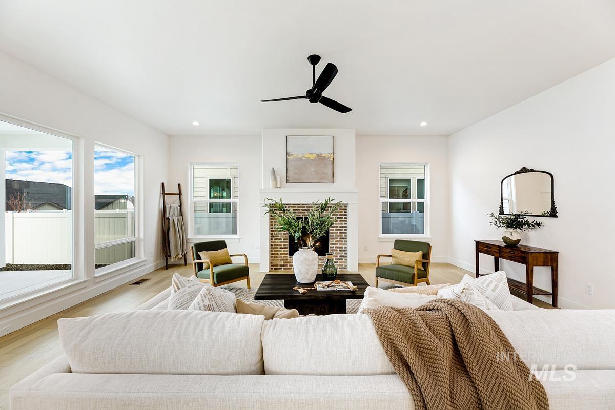 Living area with a fireplace, wood finished floors, ceiling fan, and recessed lighting