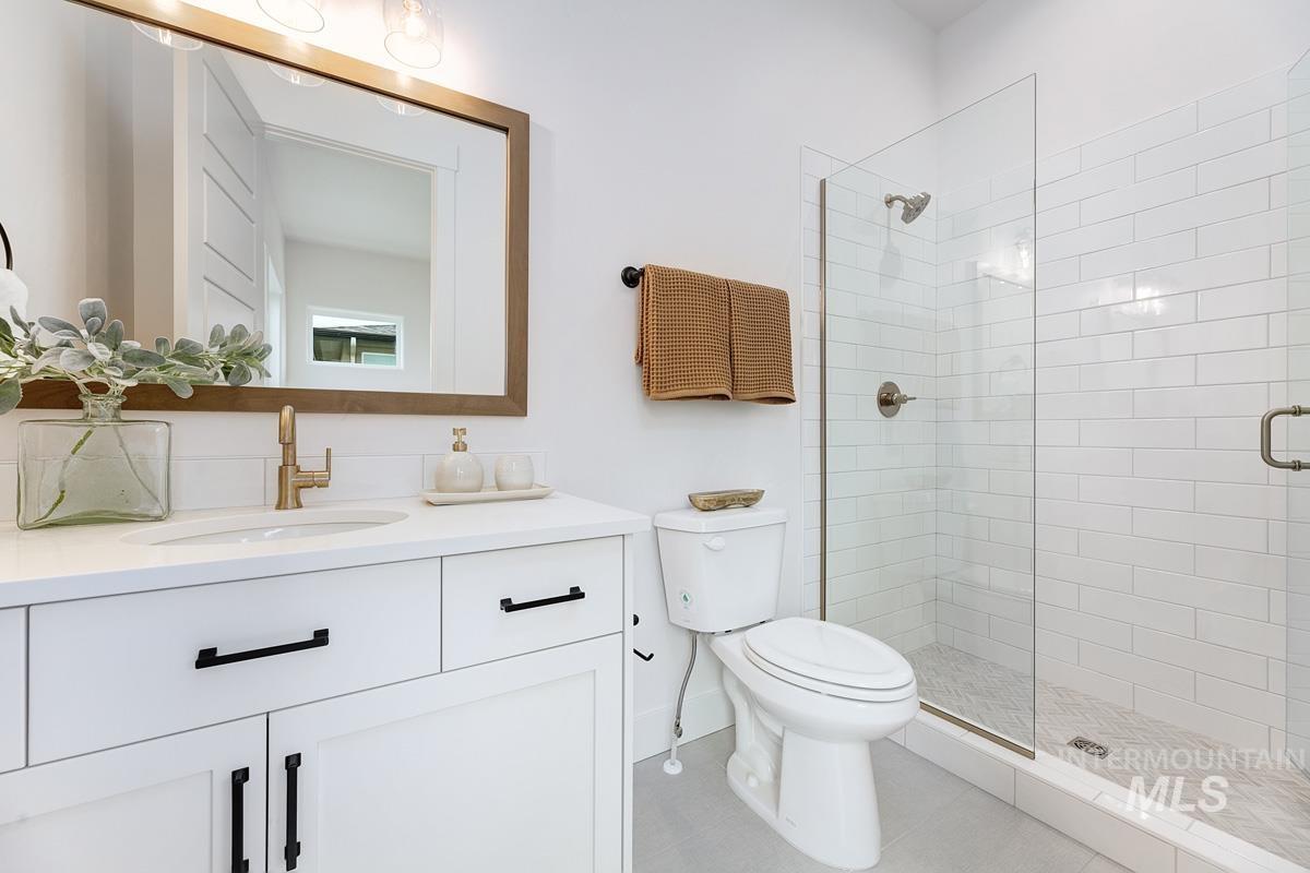 Full bath with vanity, a stall shower, and light tile patterned floors