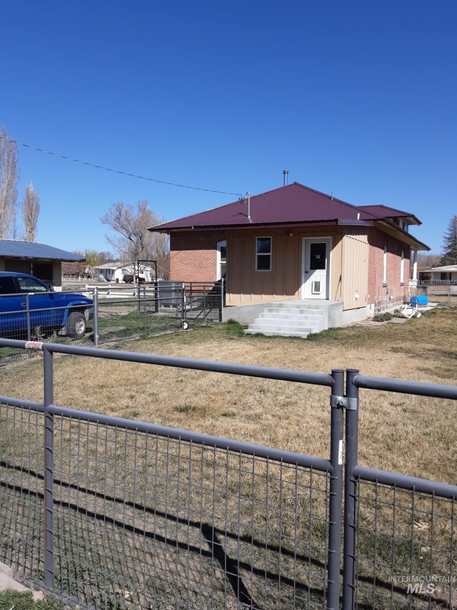 View of front of house featuring board and batten siding, a patio area, and a metal roof