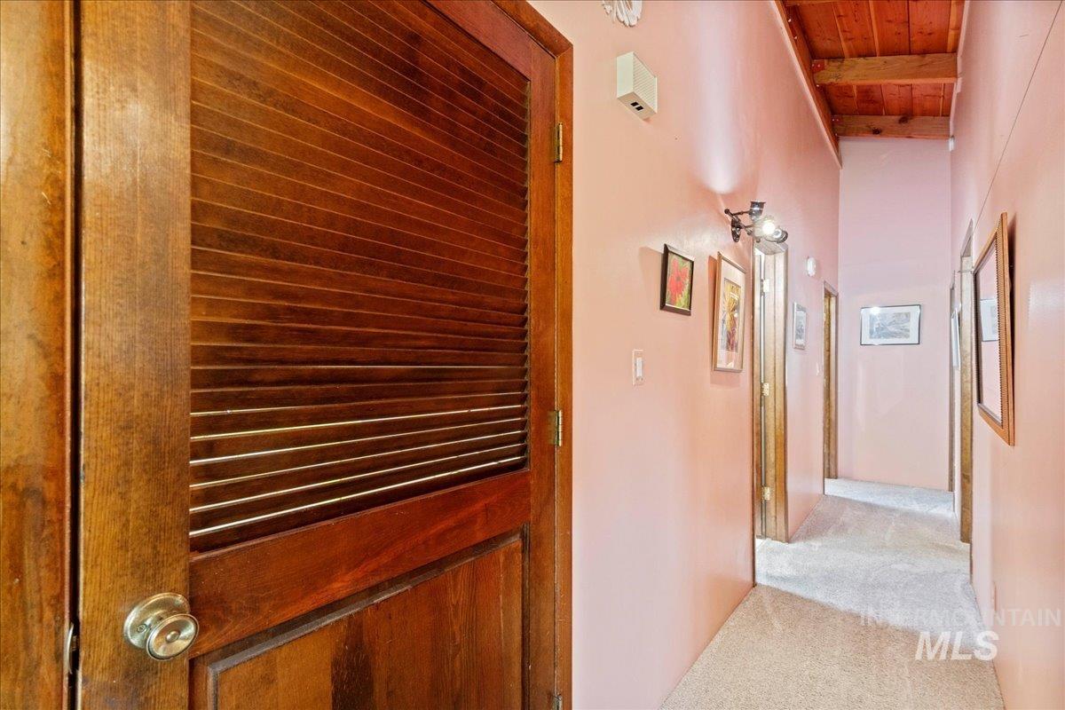 Hallway featuring carpet floors and wooden ceiling