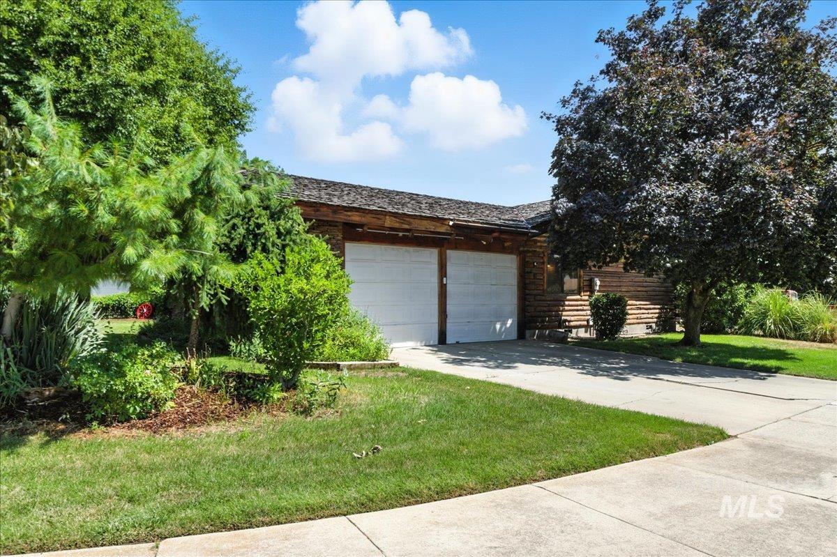View of front of home featuring concrete driveway, a garage, and a front yard