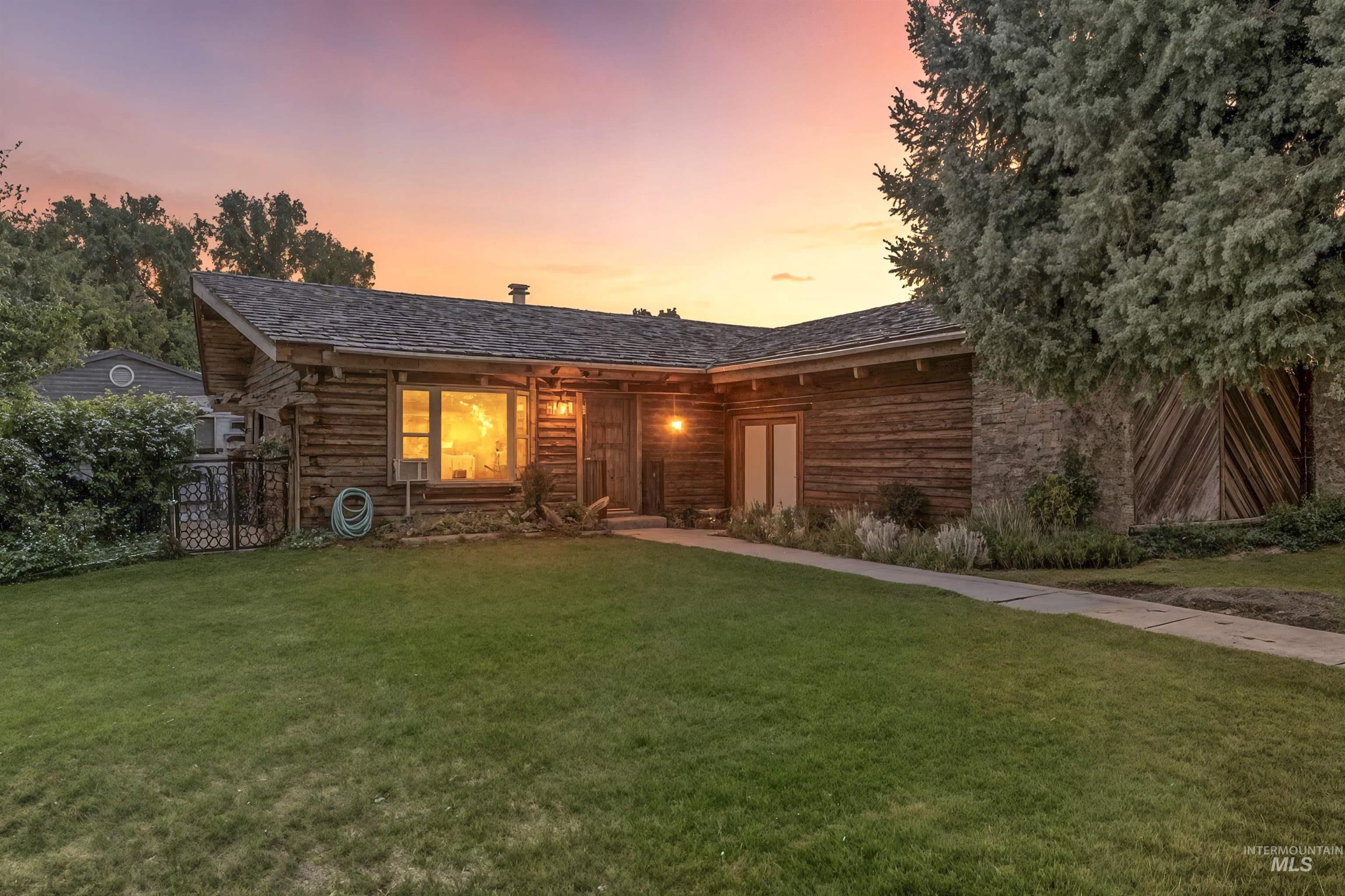 View of front of home featuring stone siding and log siding