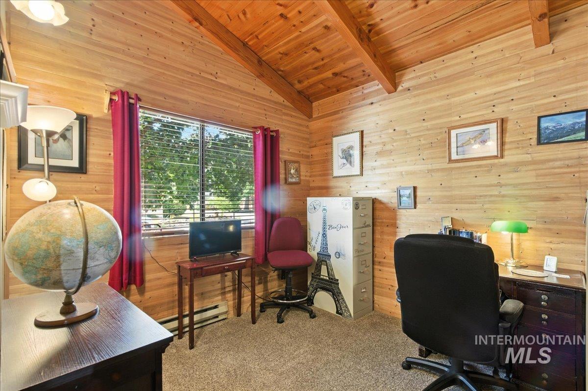 Carpeted home office featuring wooden ceiling, wood walls, and baseboard heating
