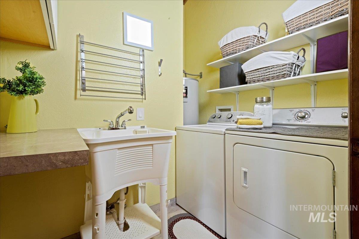 Laundry room featuring washing machine and clothes dryer and water heater