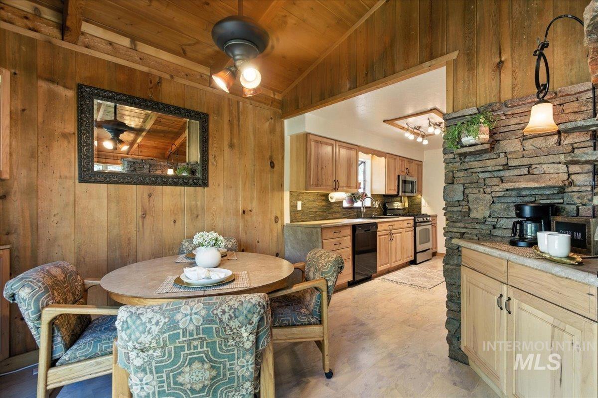 Dining area featuring lofted ceiling, wood walls, and wood ceiling