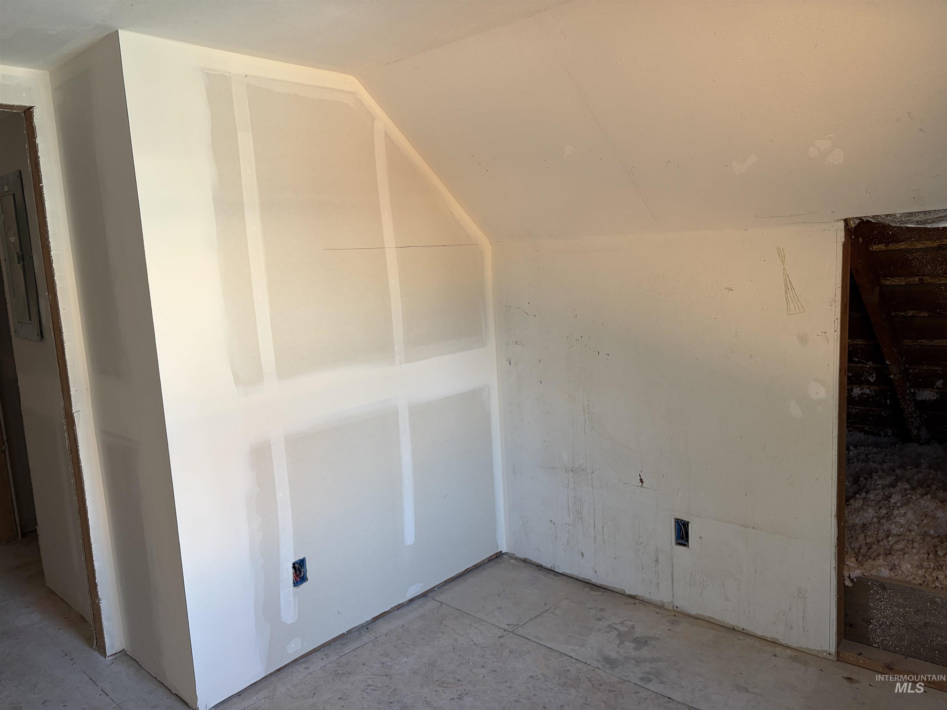 Bonus room with concrete flooring and lofted ceiling