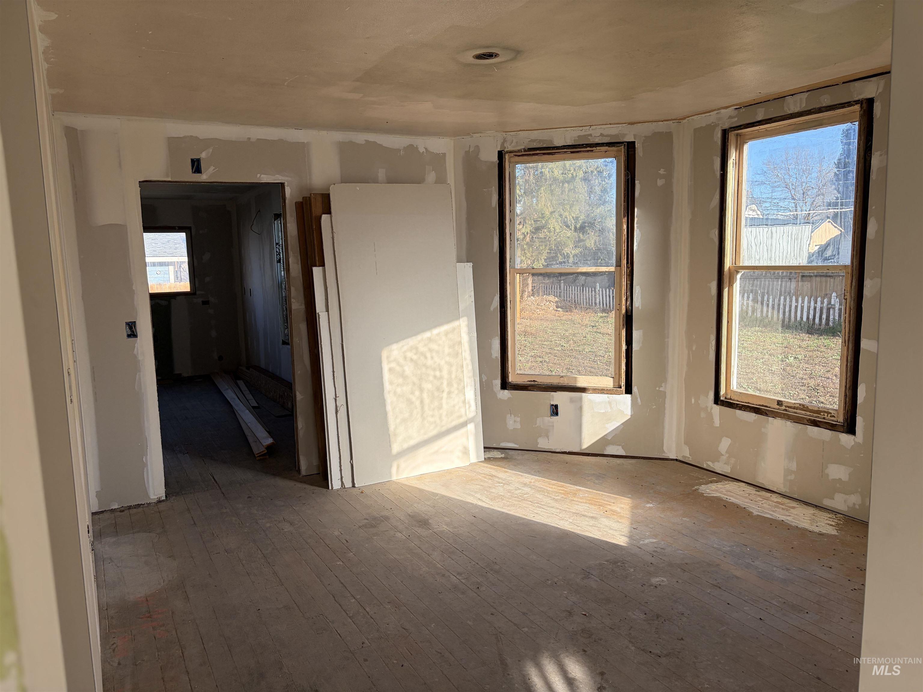 Empty room with hardwood / wood-style flooring and plenty of natural light