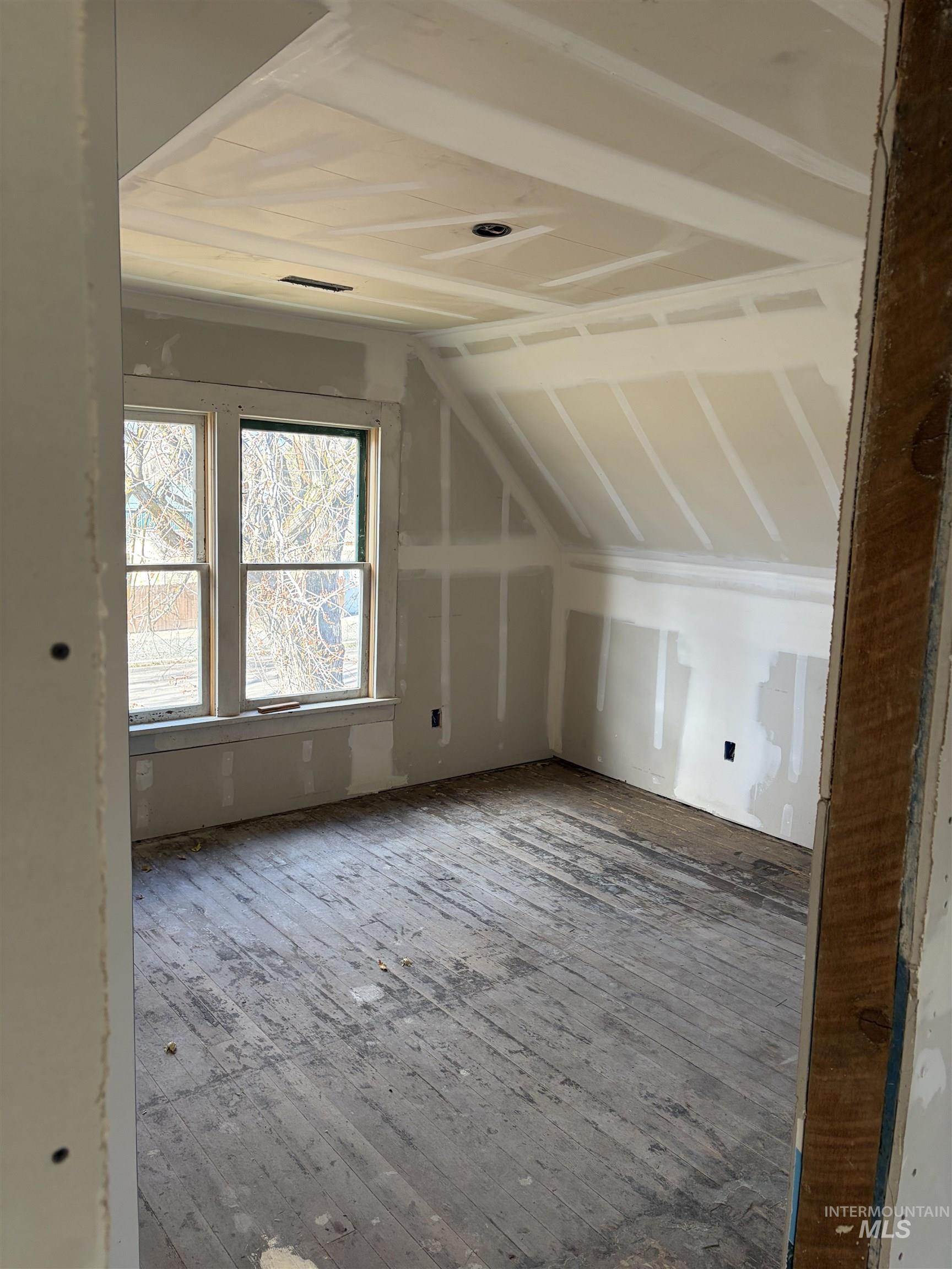 Bonus room with vaulted ceiling and hardwood / wood-style flooring