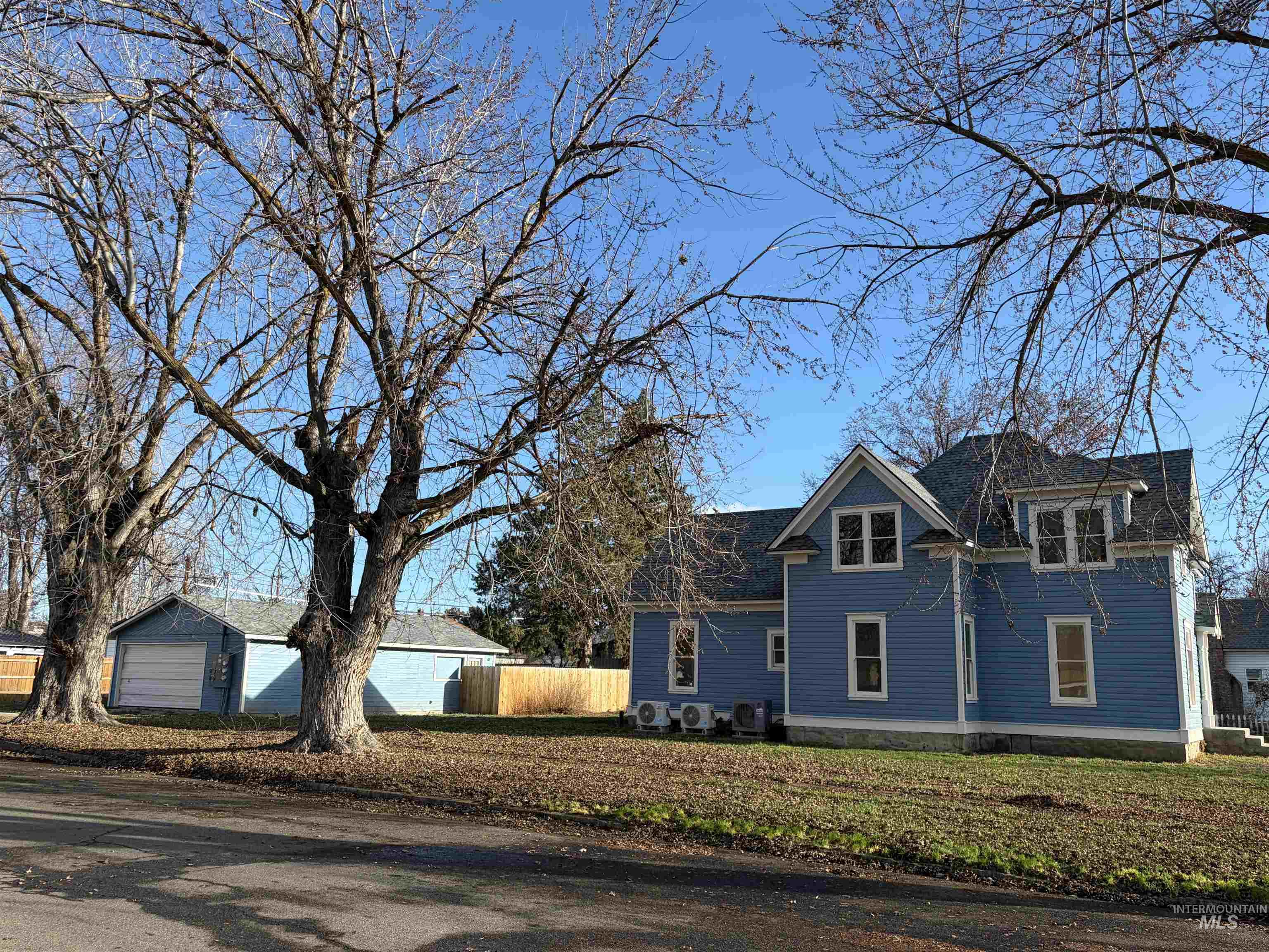 View of front of property with a detached garage and an outdoor structure