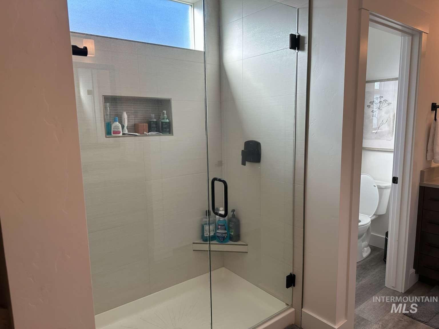 Bathroom featuring a stall shower and wood finished floors