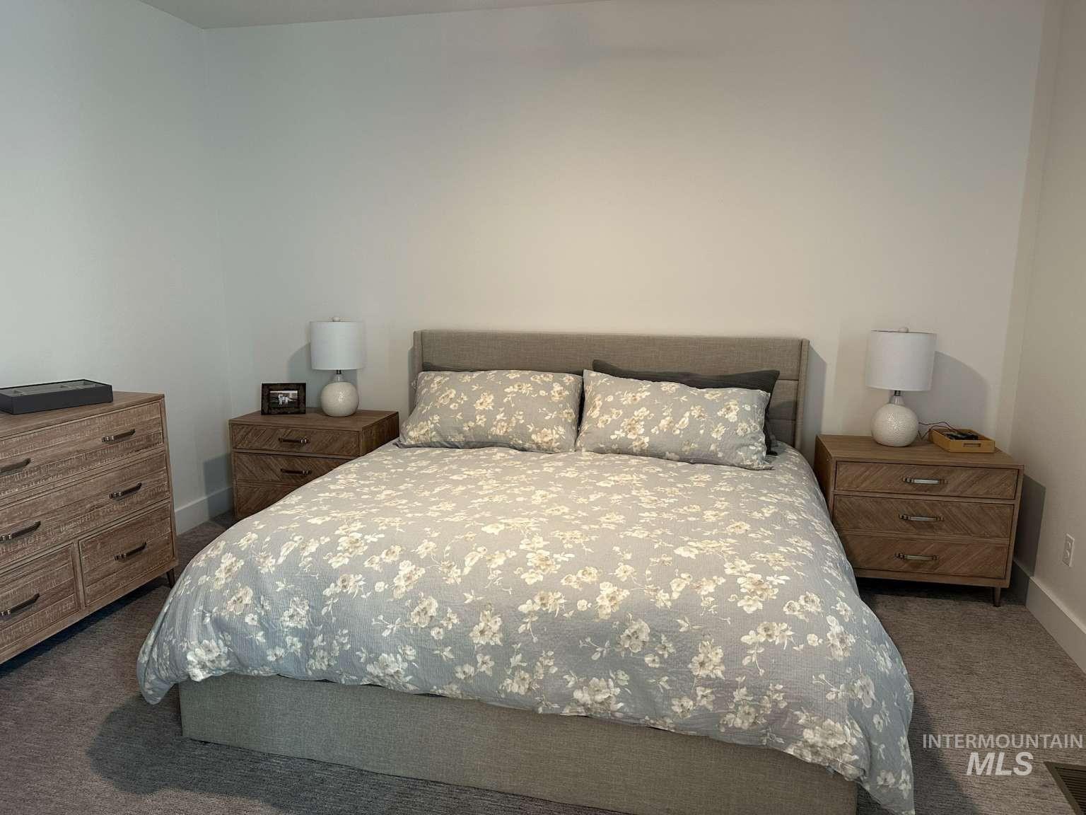 Bedroom featuring dark carpet and baseboards