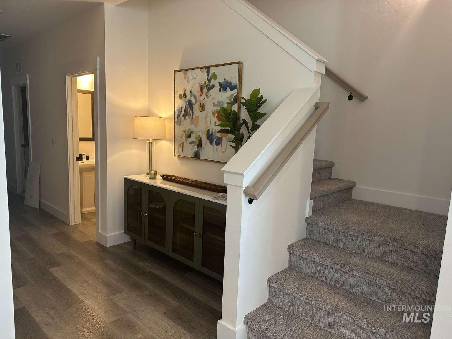 Stairway featuring baseboards and wood finished floors