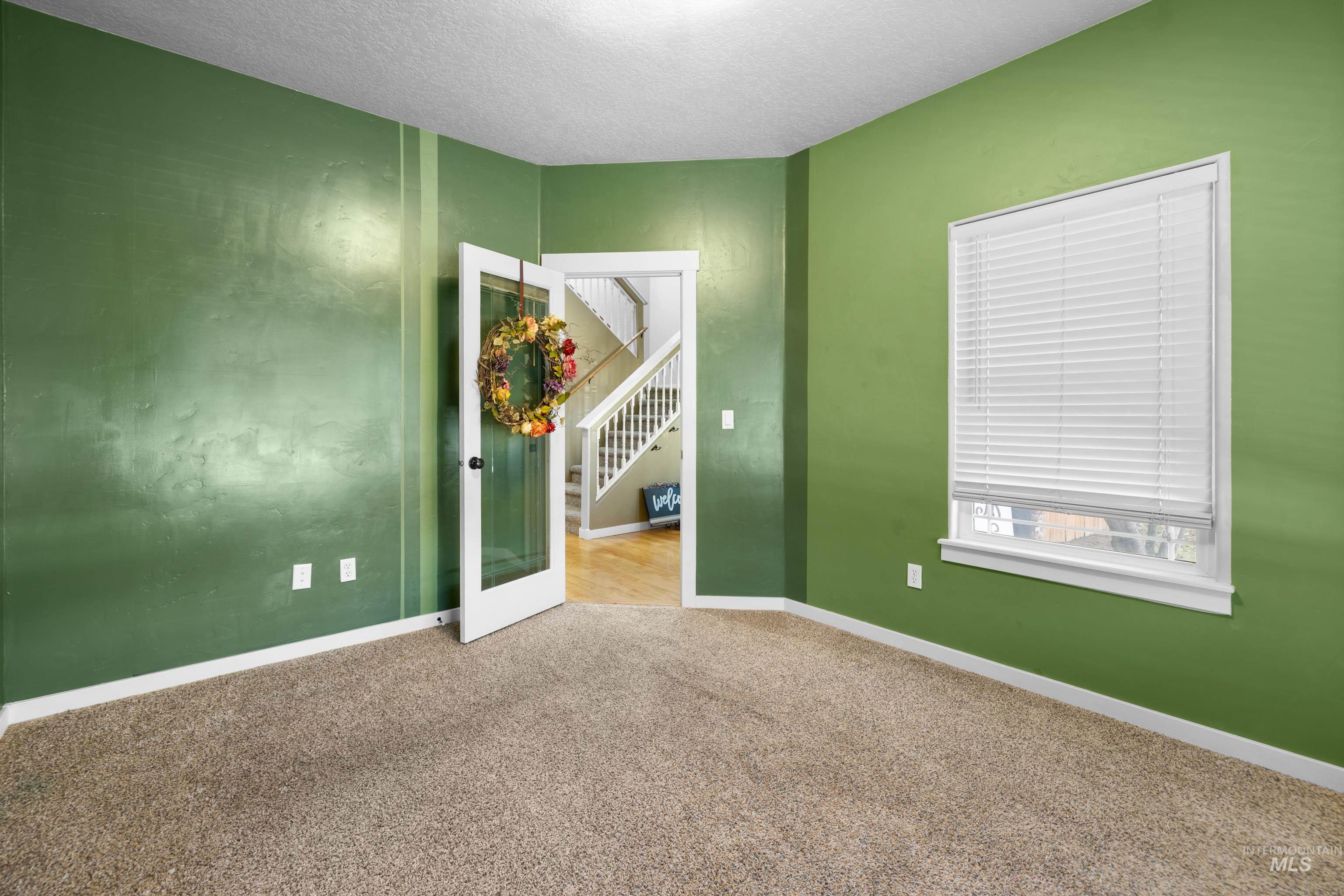 Unfurnished bedroom featuring light carpet and a textured ceiling