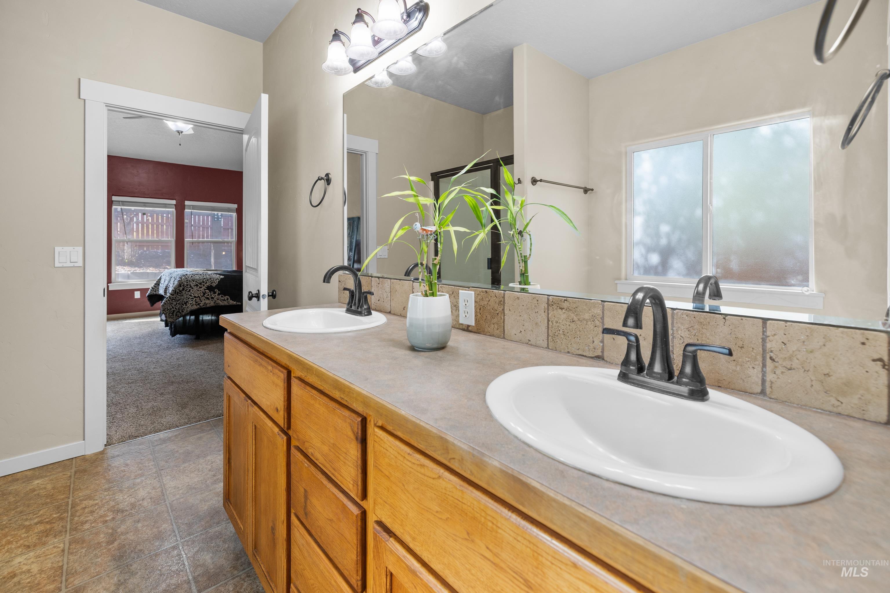 Ensuite bathroom featuring double vanity and plenty of natural light