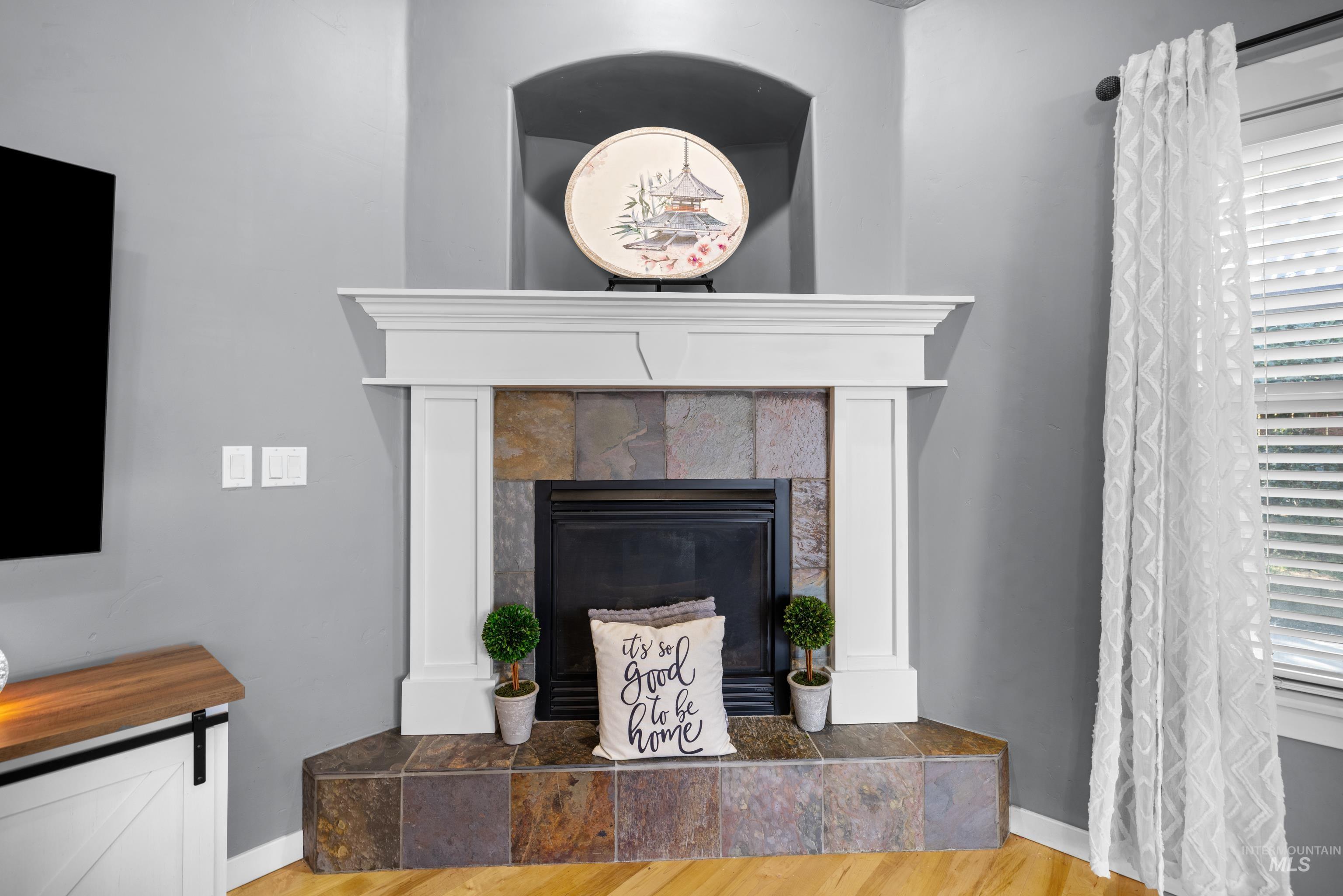 Detailed view of wood finished floors and a tiled fireplace