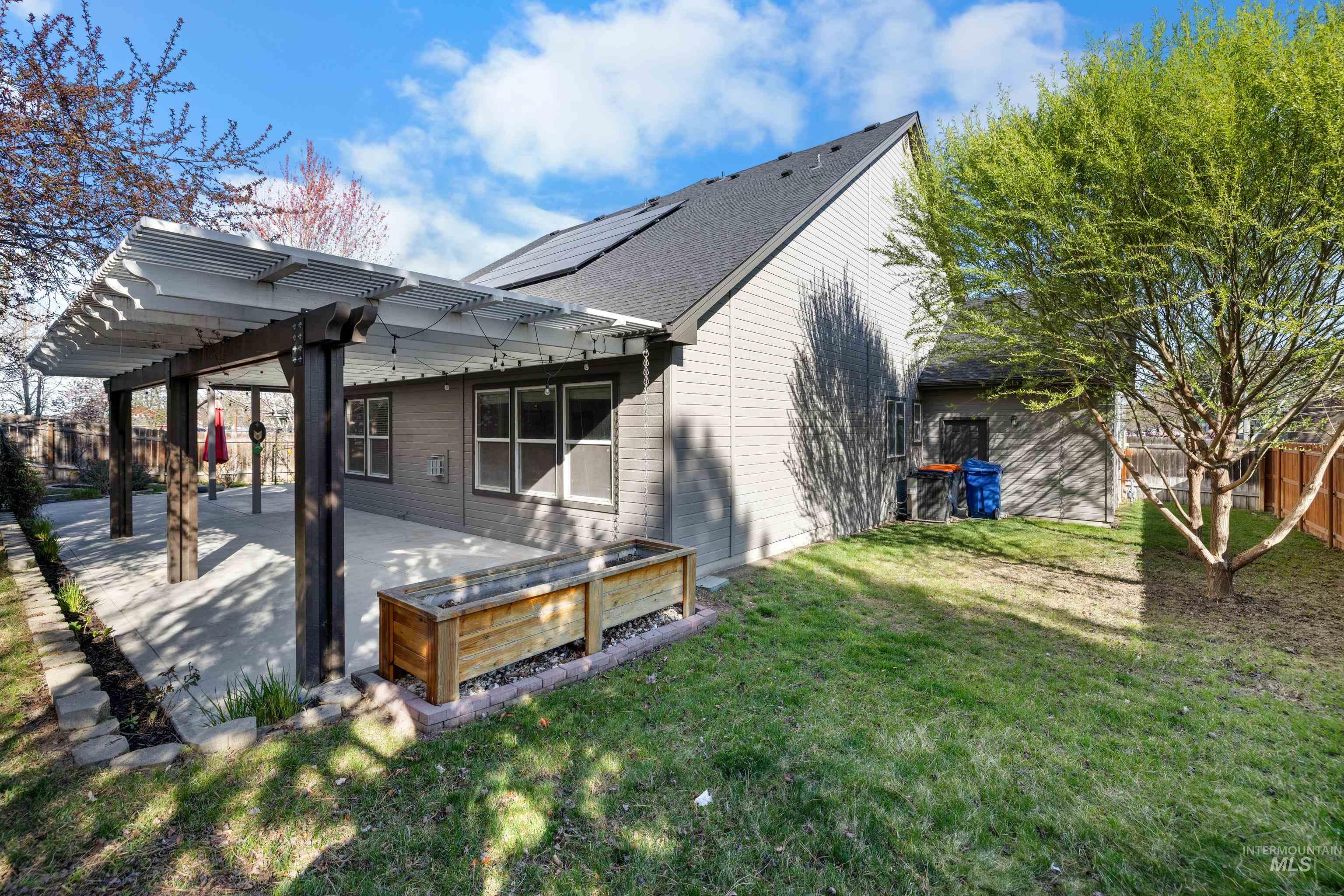 Rear view of property featuring a fenced backyard, a pergola, a patio, and roof with shingles
