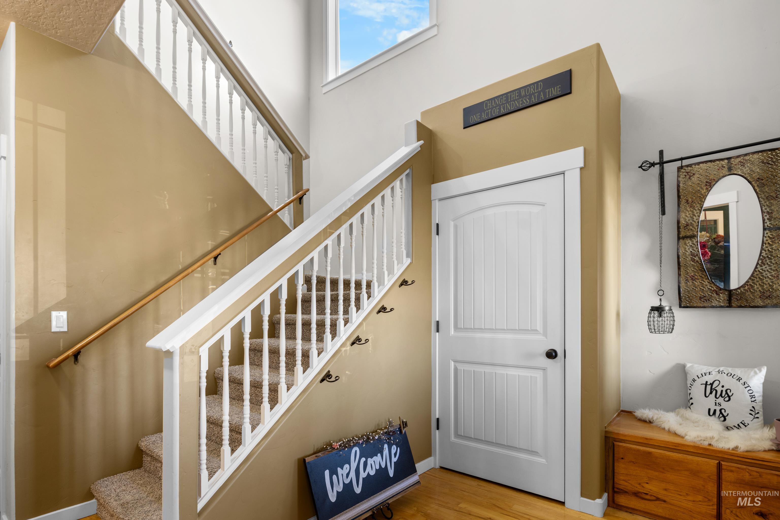 Stairs with wood finished floors and baseboards