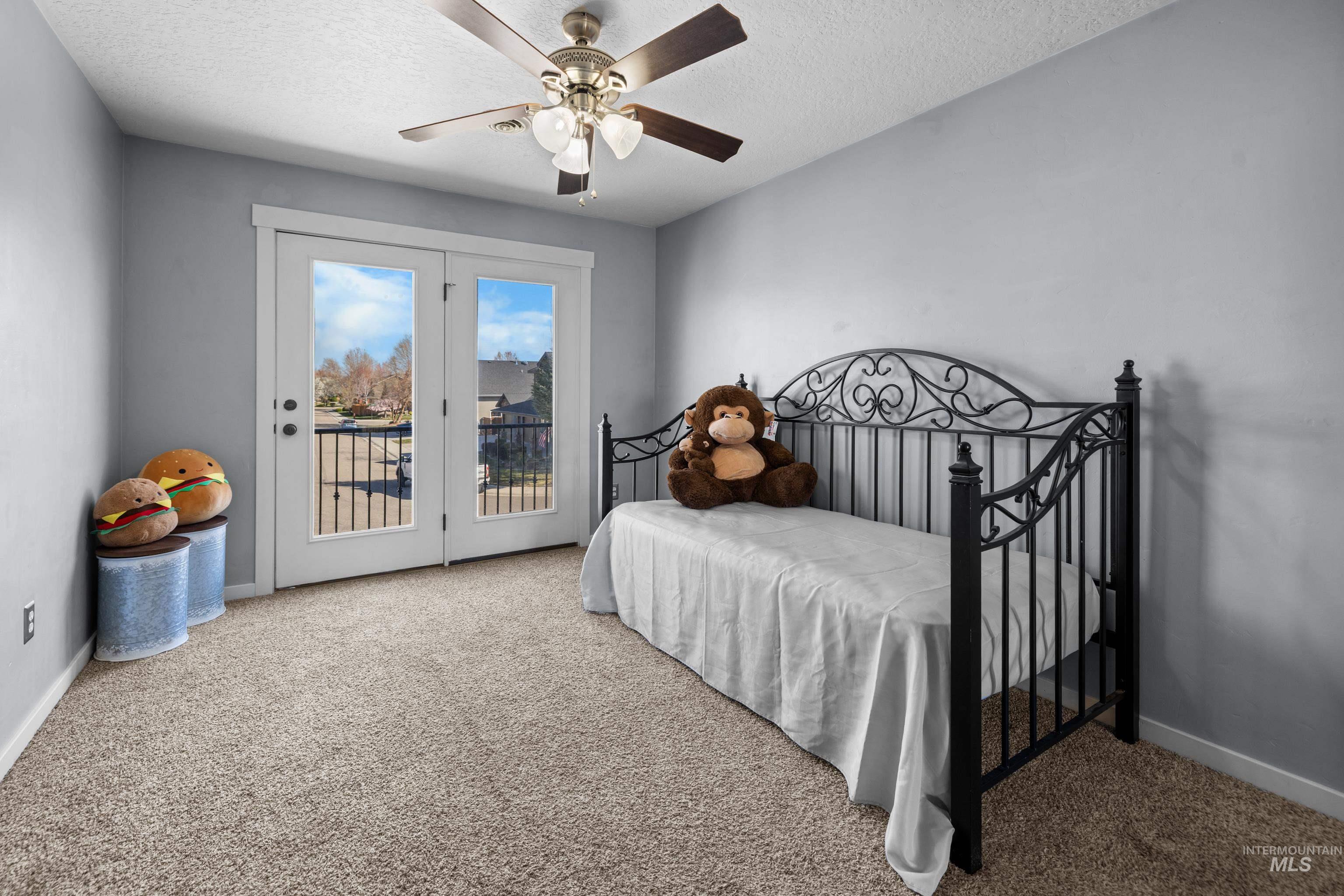 Bedroom featuring access to outside, a textured ceiling, light colored carpet, and ceiling fan