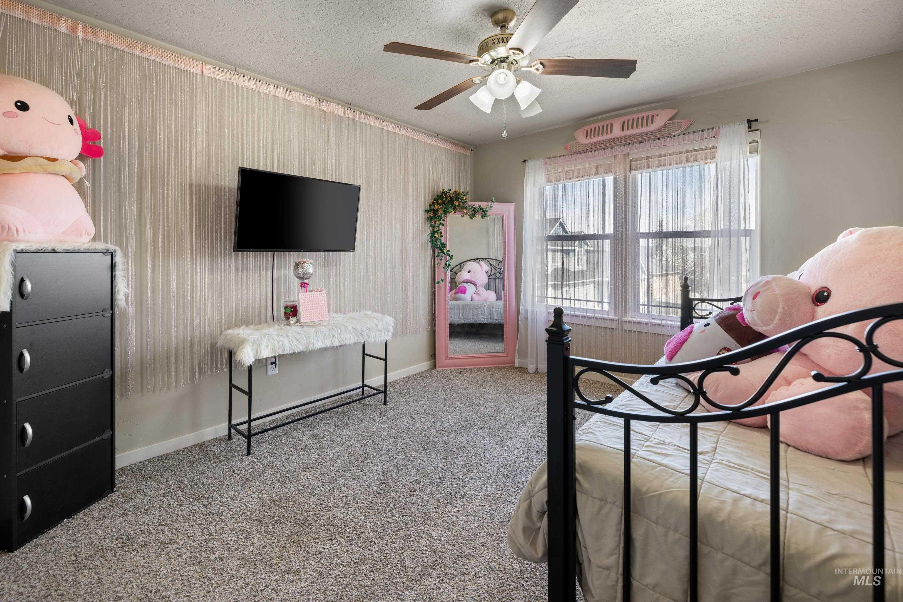 Bedroom featuring light colored carpet, a textured ceiling, ceiling fan, and wallpapered walls