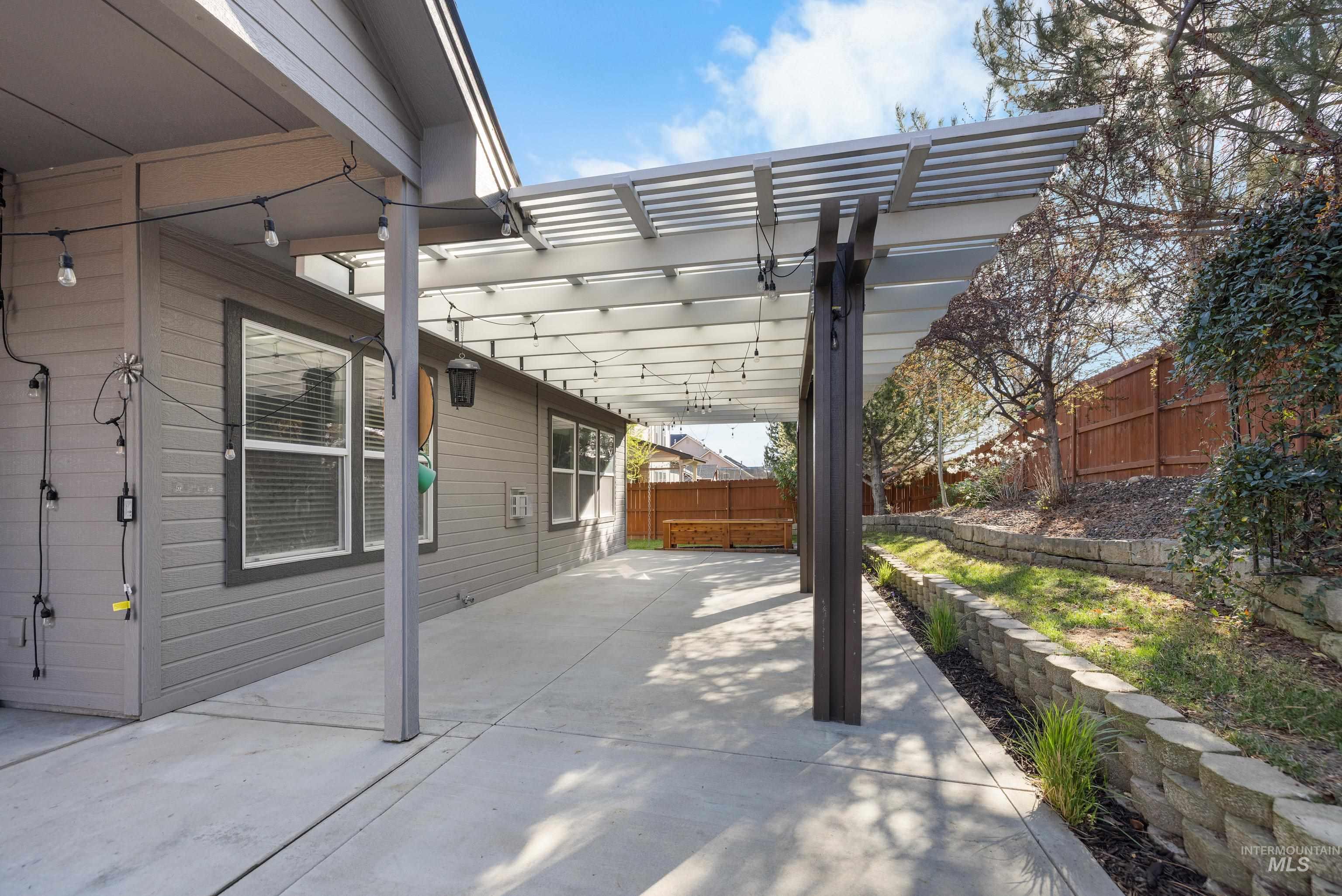 Fenced backyard with a pergola and a patio area