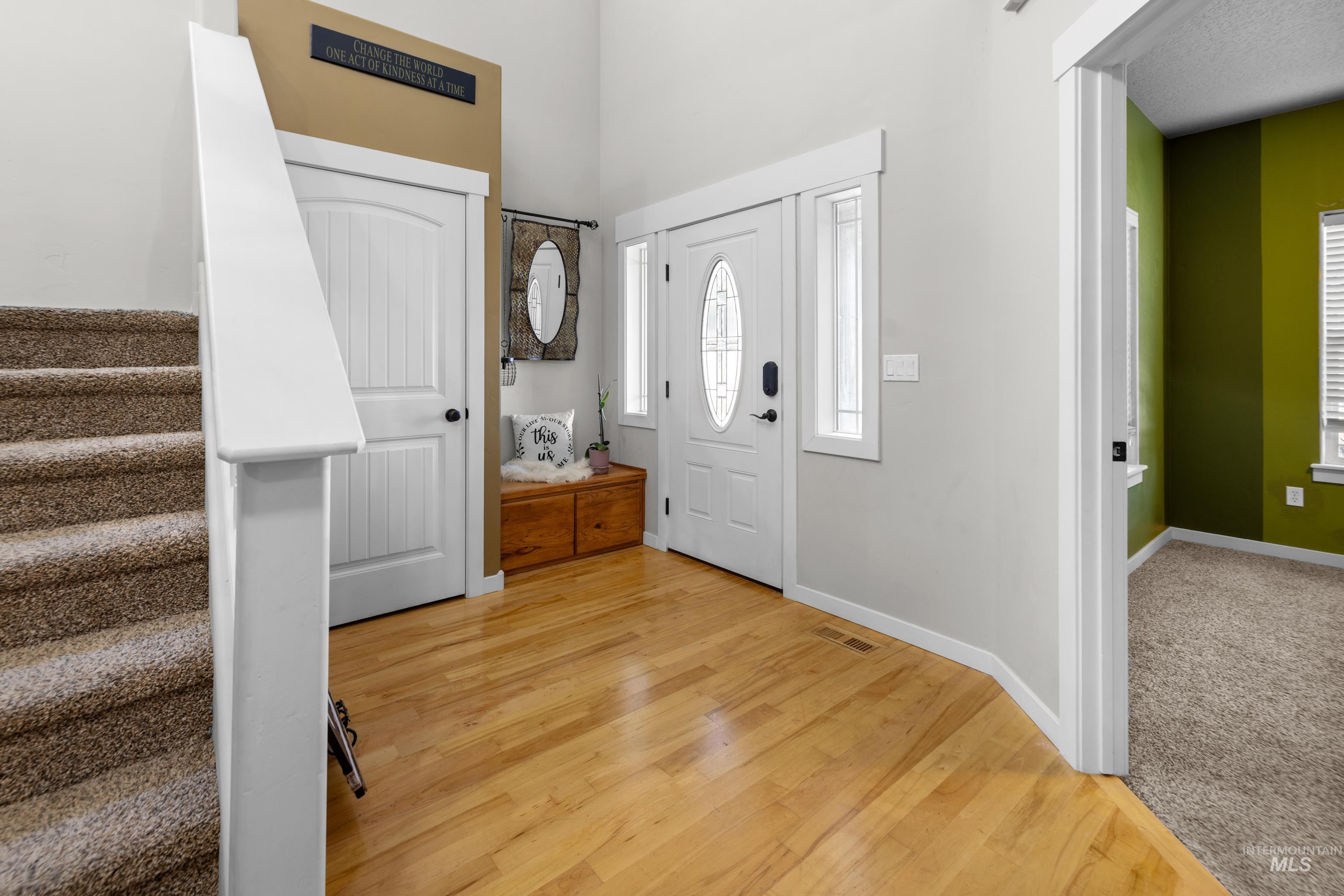 Foyer entrance with stairs and light wood finished floors