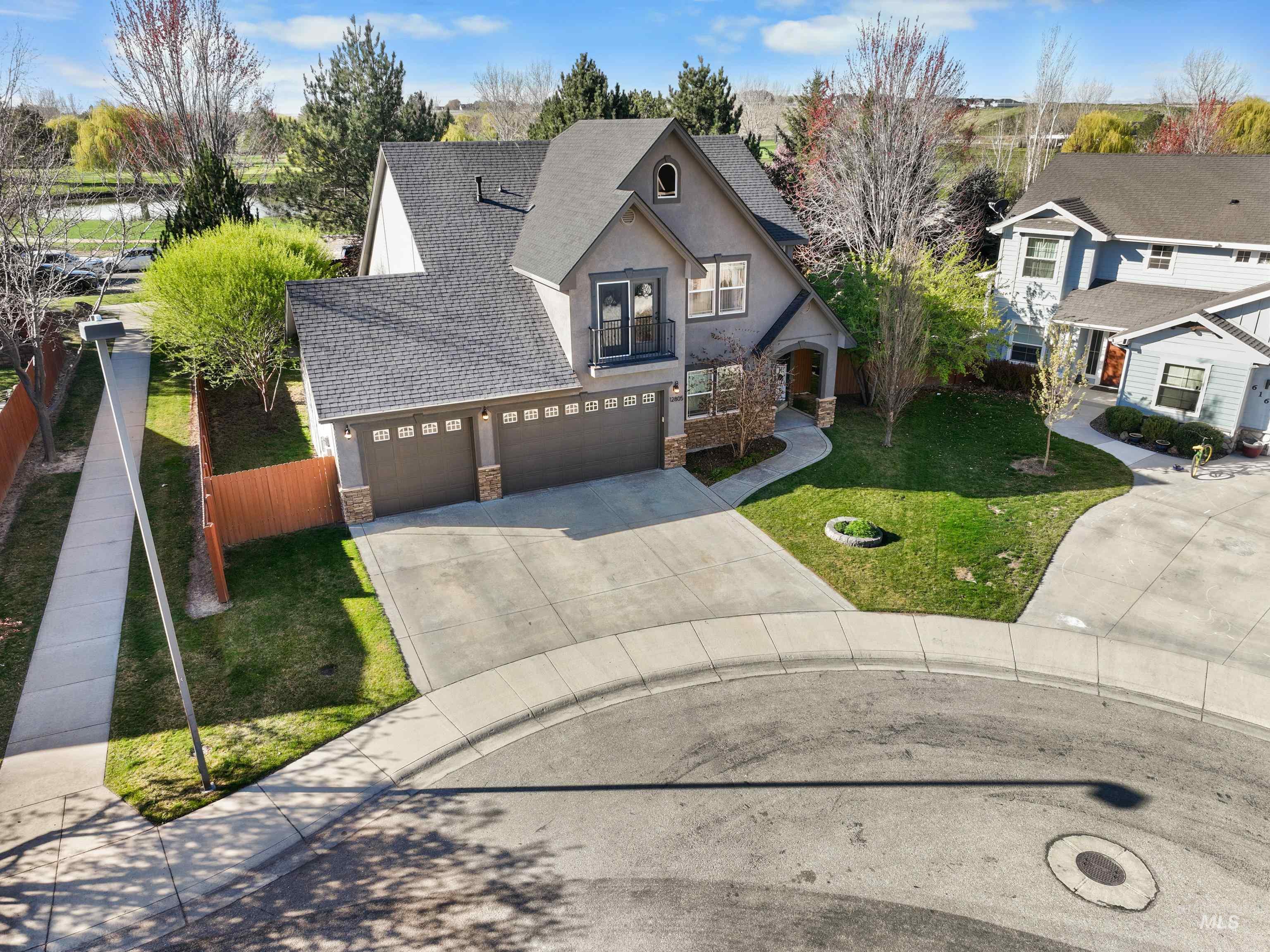 View of front of property featuring a shingled roof, stone siding, concrete driveway, stucco siding, and an attached garage