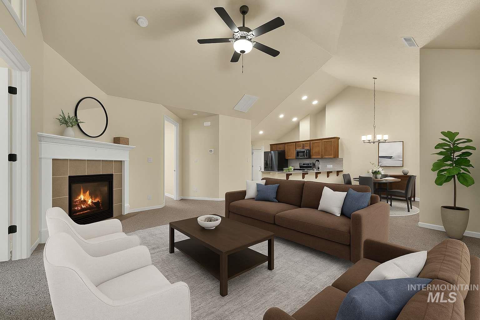 Living area featuring light colored carpet, high vaulted ceiling, a chandelier, a tiled fireplace, and a ceiling fan