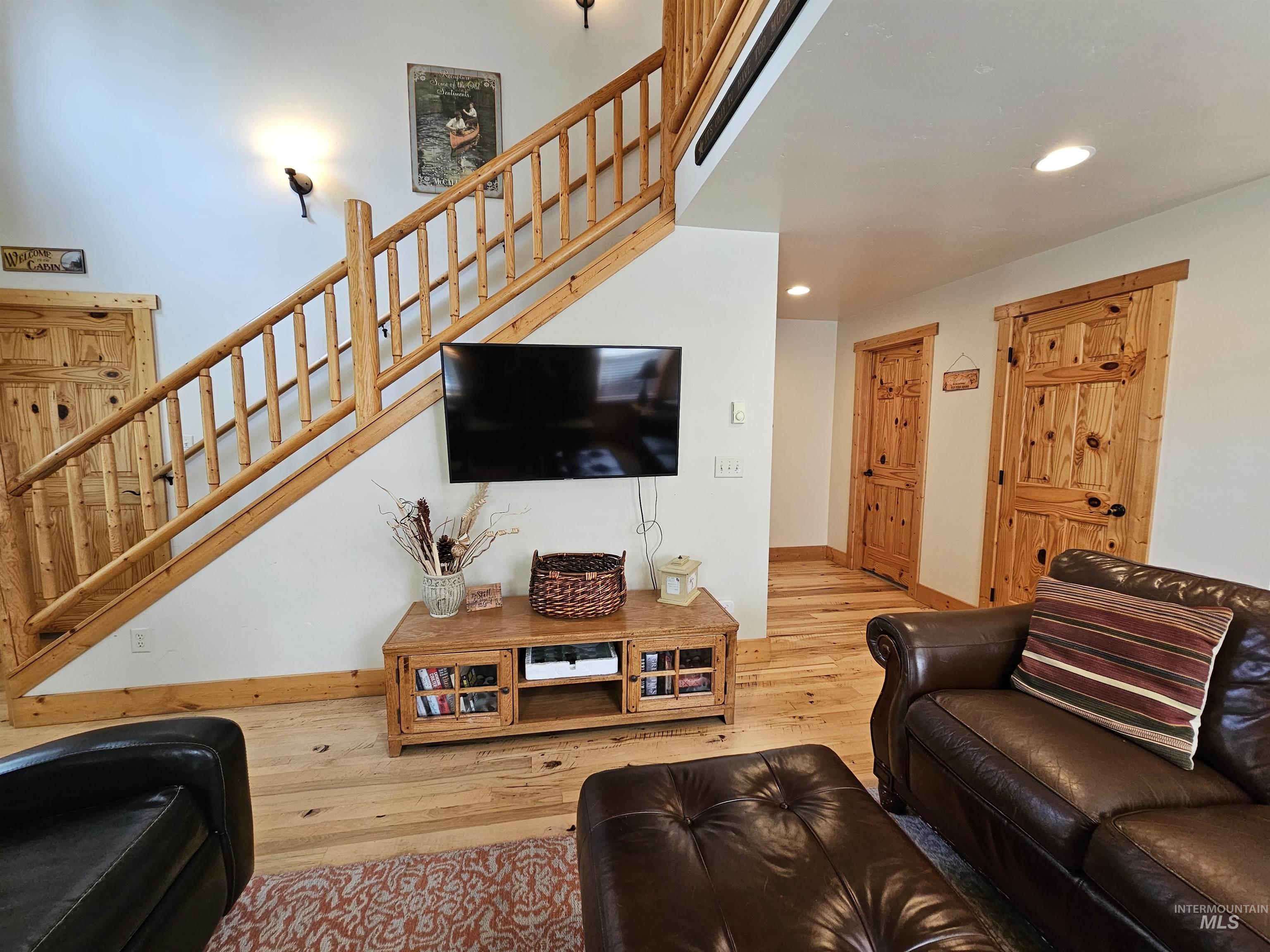 Living room with stairway, hardwood / wood-style floors, and recessed lighting