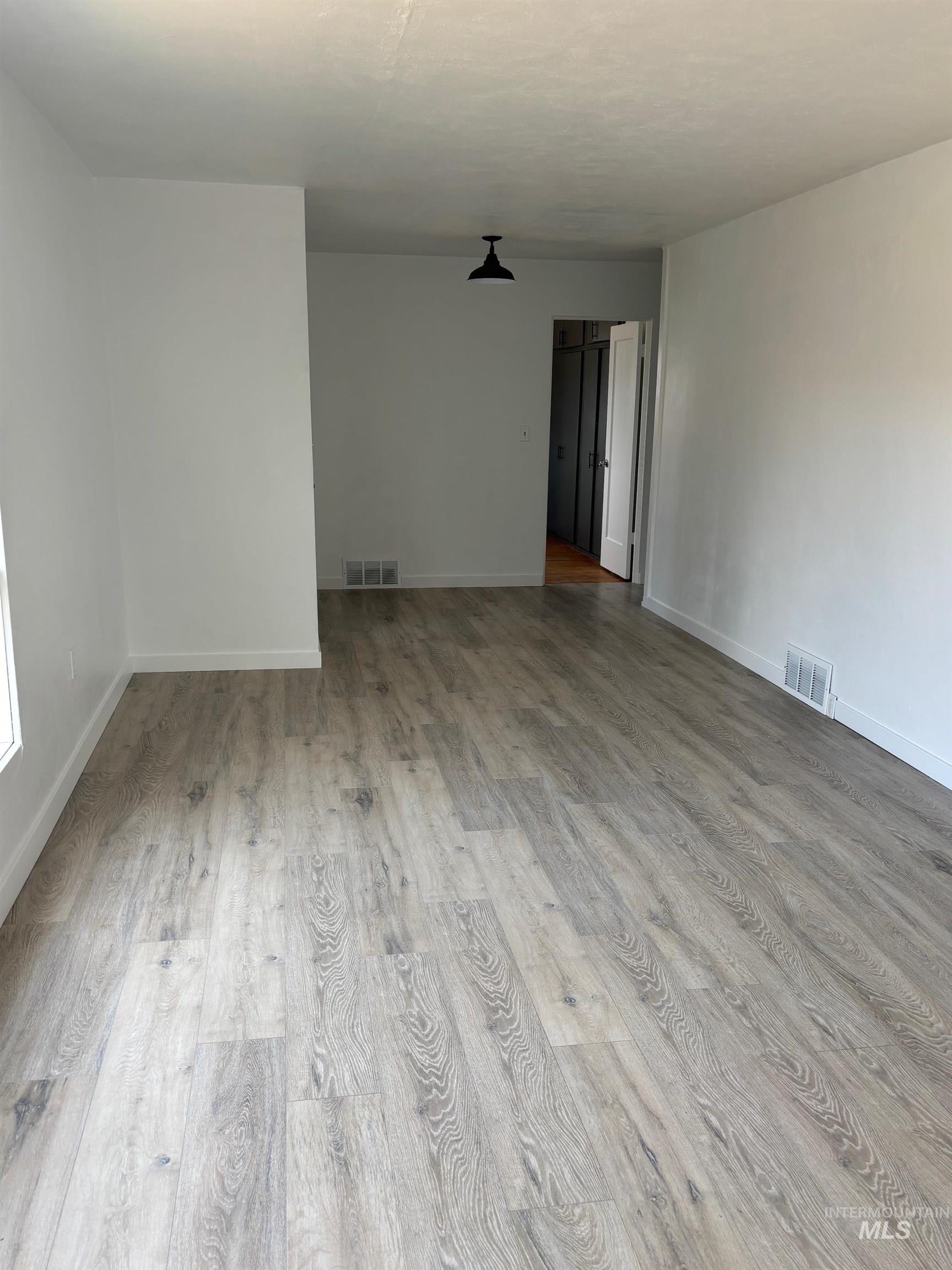 Unfurnished room with wood finished floors and baseboards