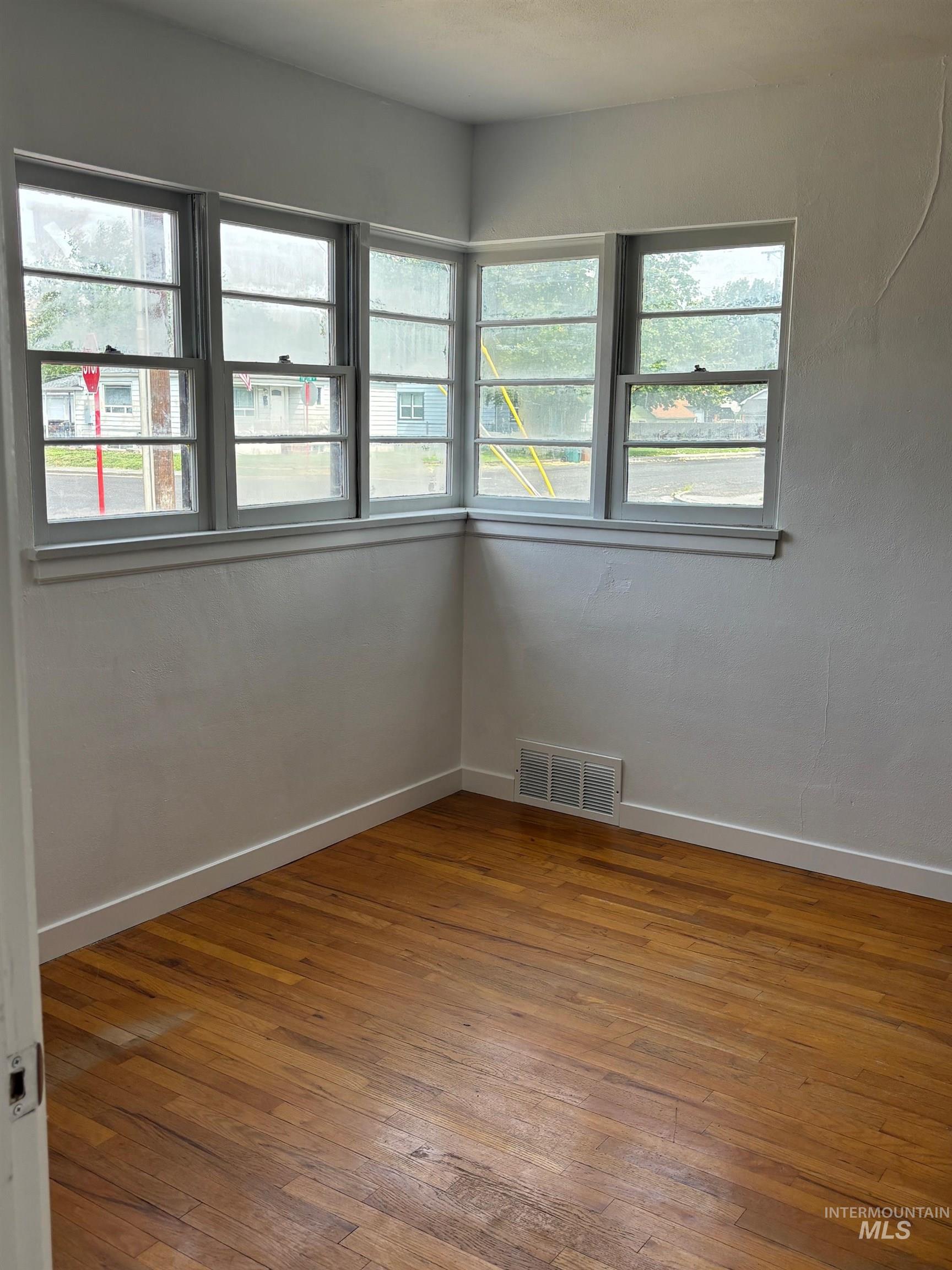 Unfurnished room featuring wood-type flooring and baseboards