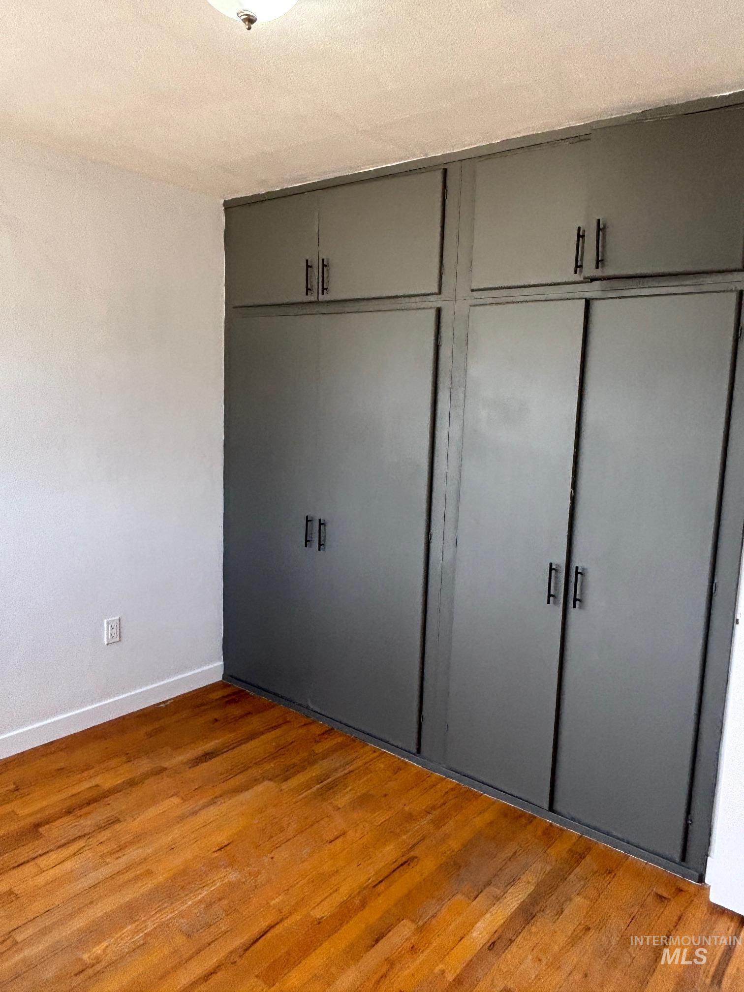 Unfurnished bedroom featuring light wood-style flooring, a closet, and a textured ceiling