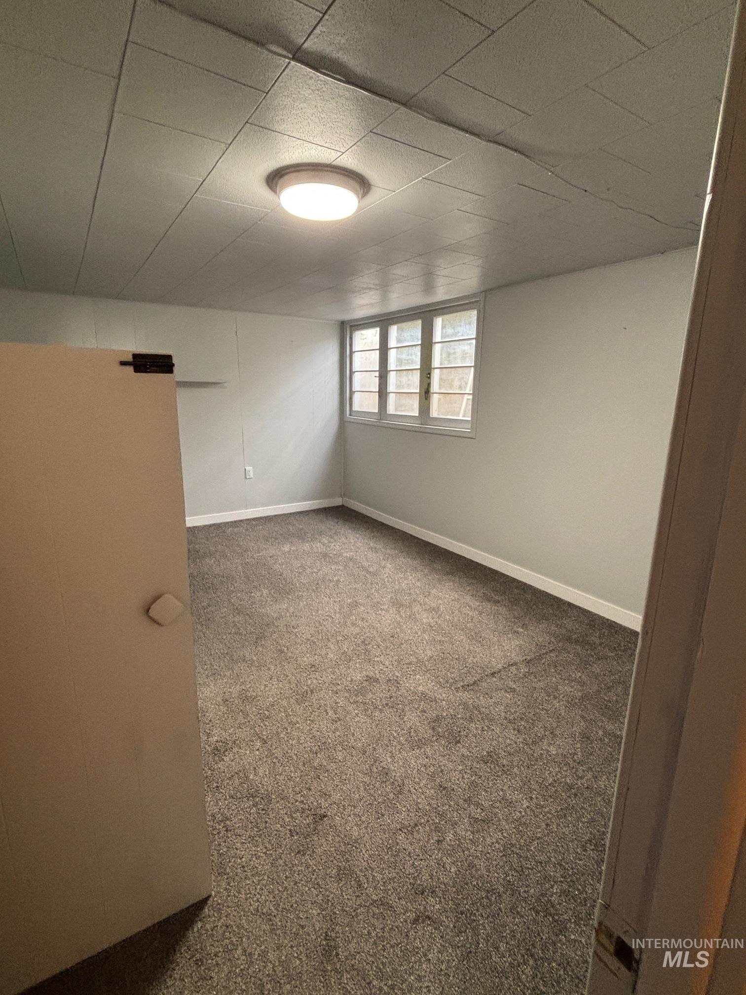 Empty room with carpet and baseboards