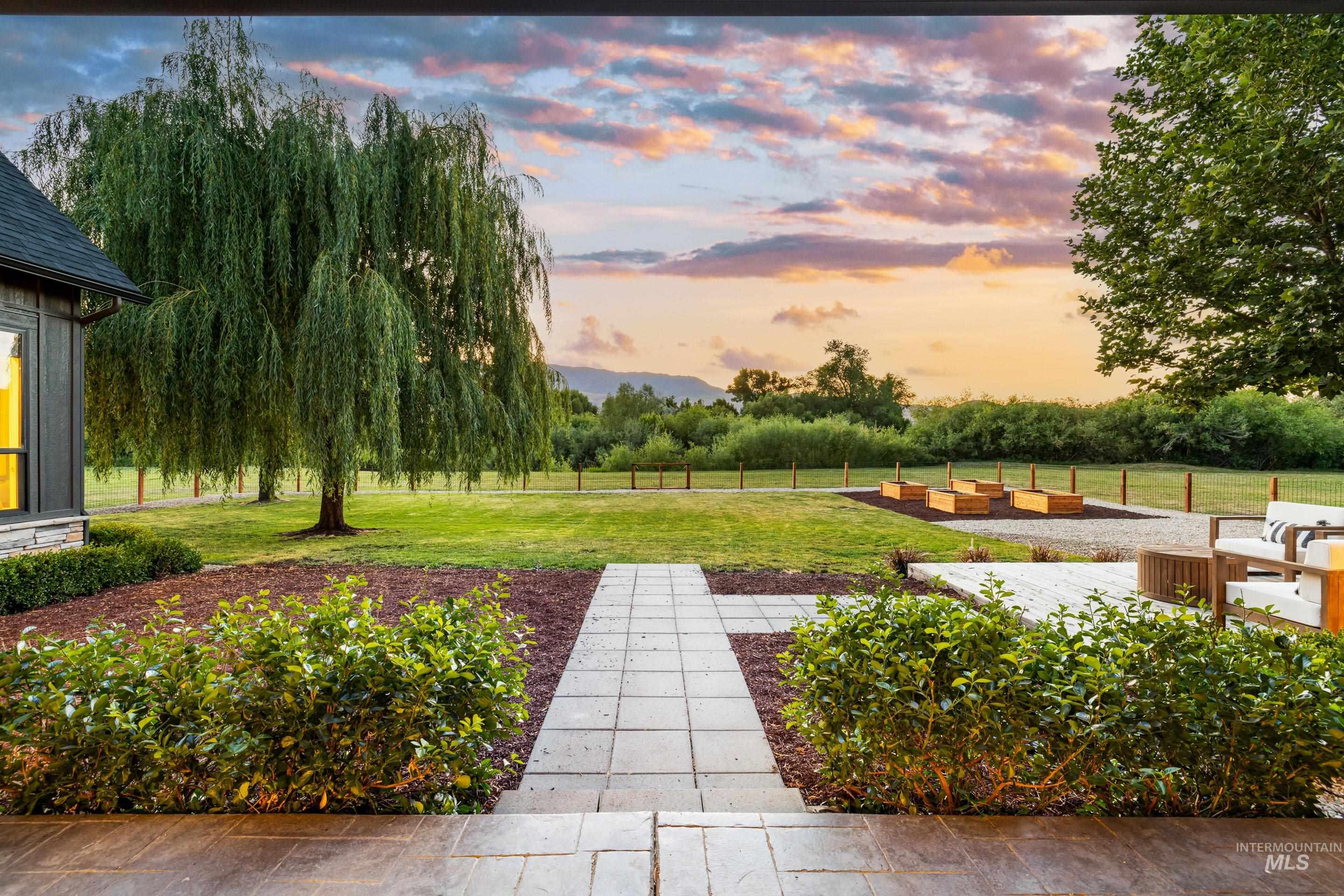 View of grassy yard with view of wooded area and a rural view