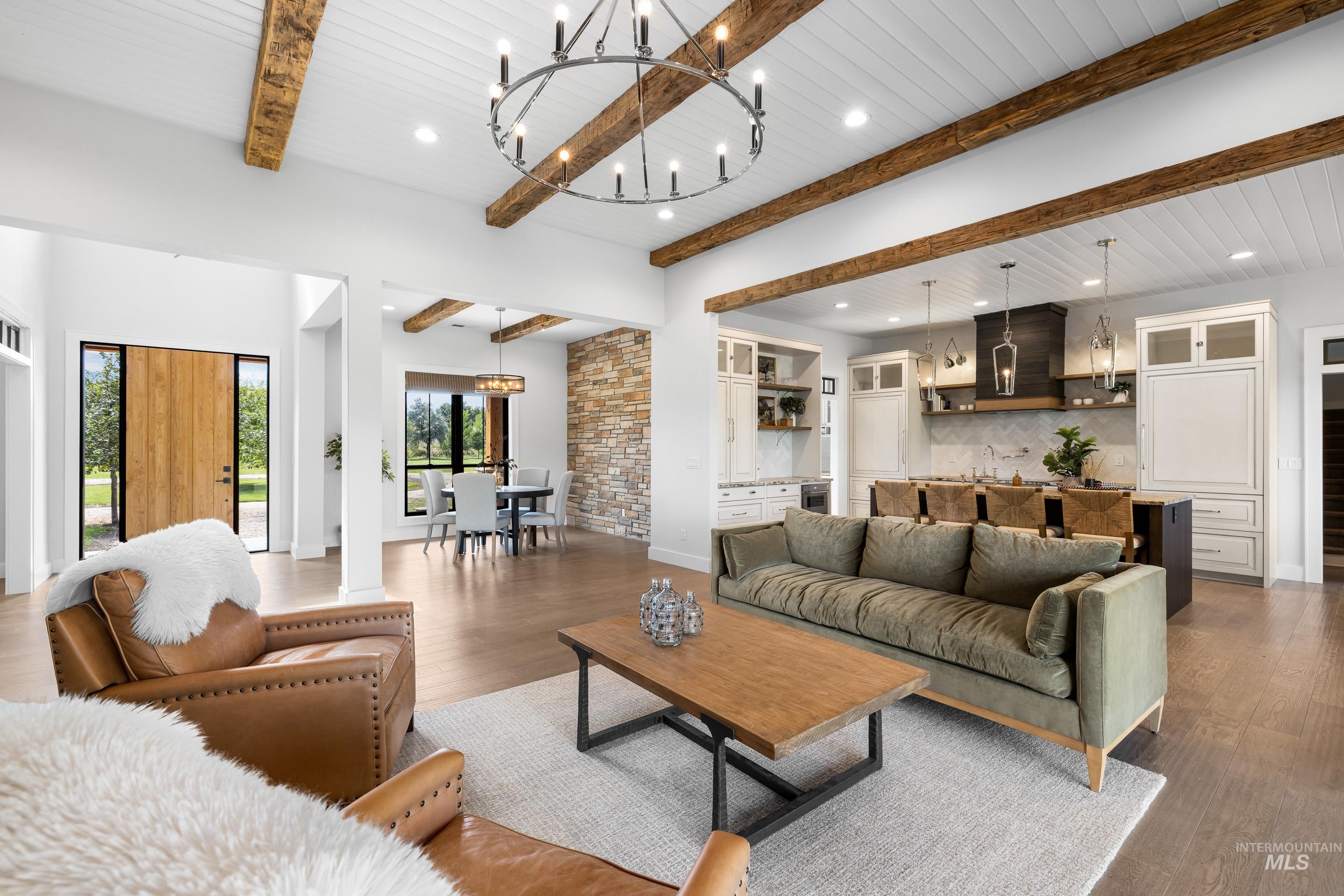 Living area with beam ceiling, a chandelier, wood finished floors, and recessed lighting