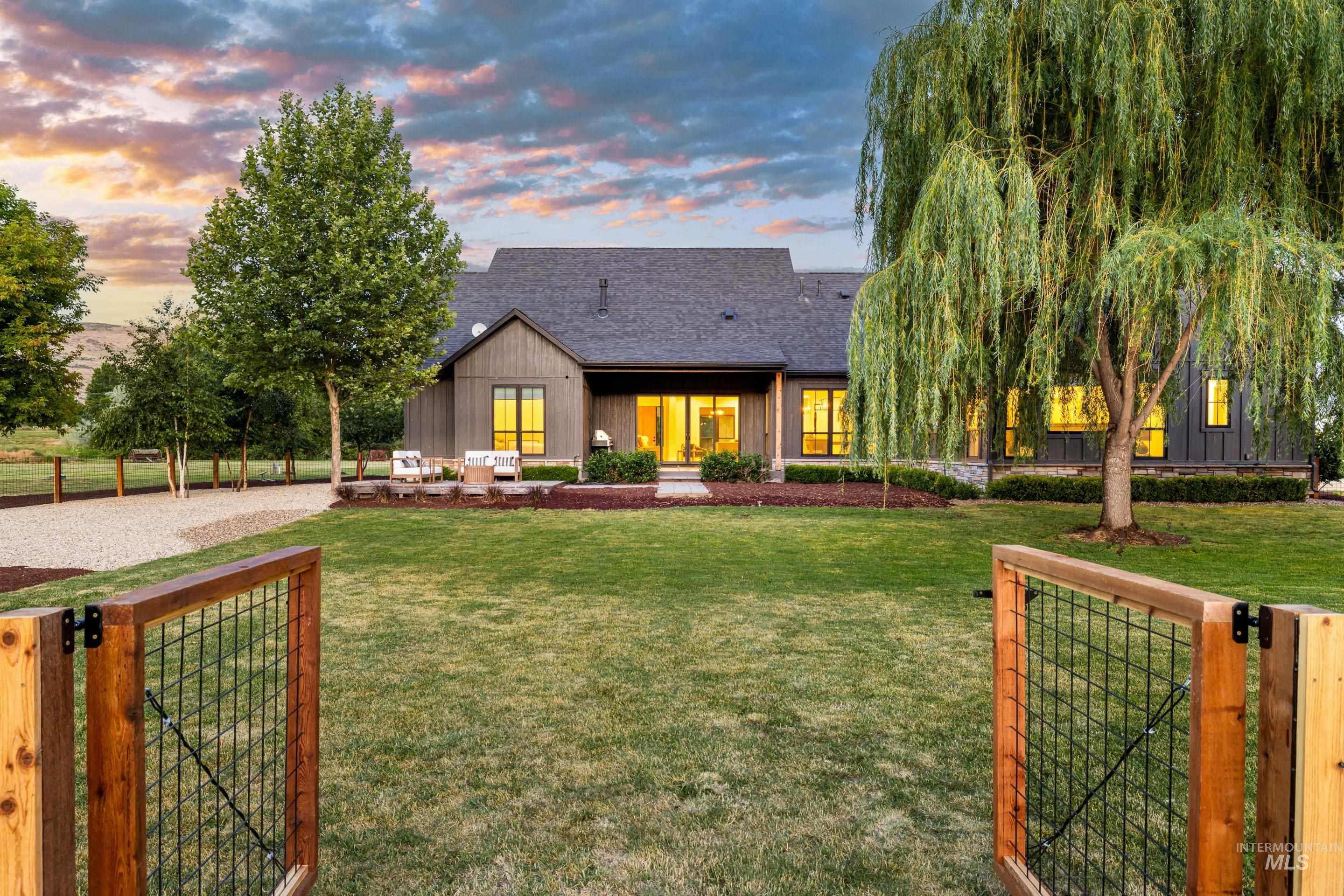 View of front of property featuring a gate and roof with shingles