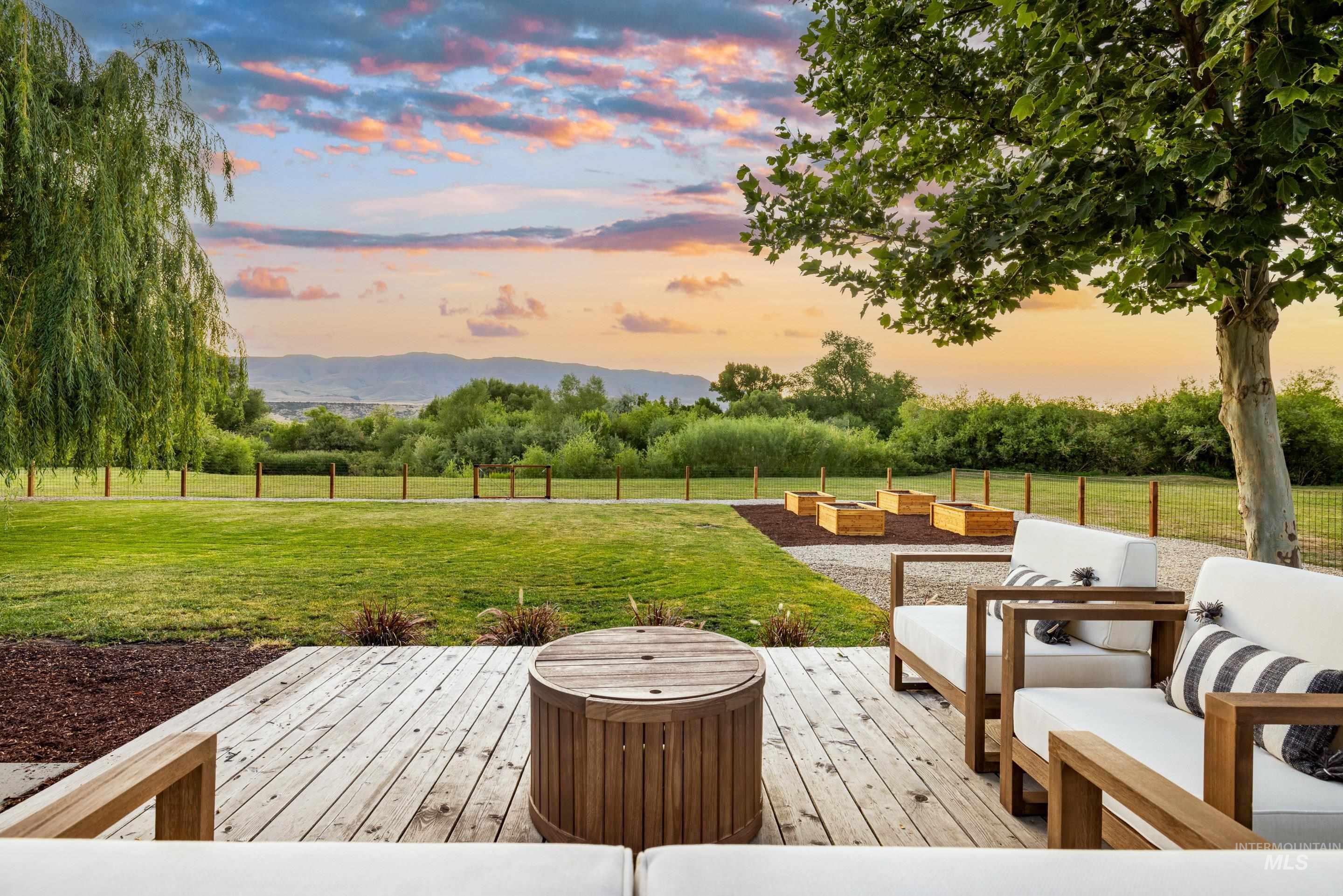 Wooden deck featuring view of scattered trees and an outdoor hangout area