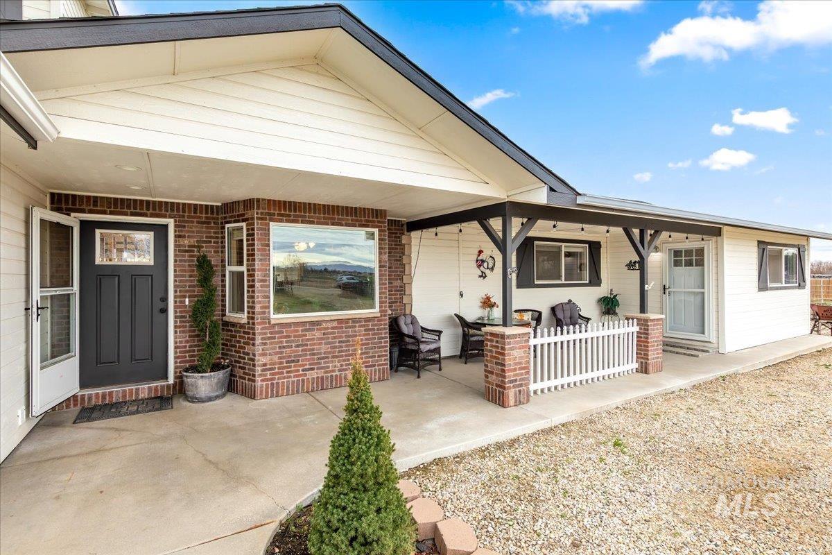 Doorway to property featuring brick siding and a patio area