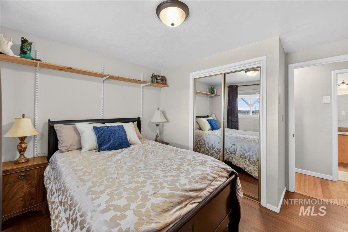 Bedroom with dark wood finished floors and a closet
