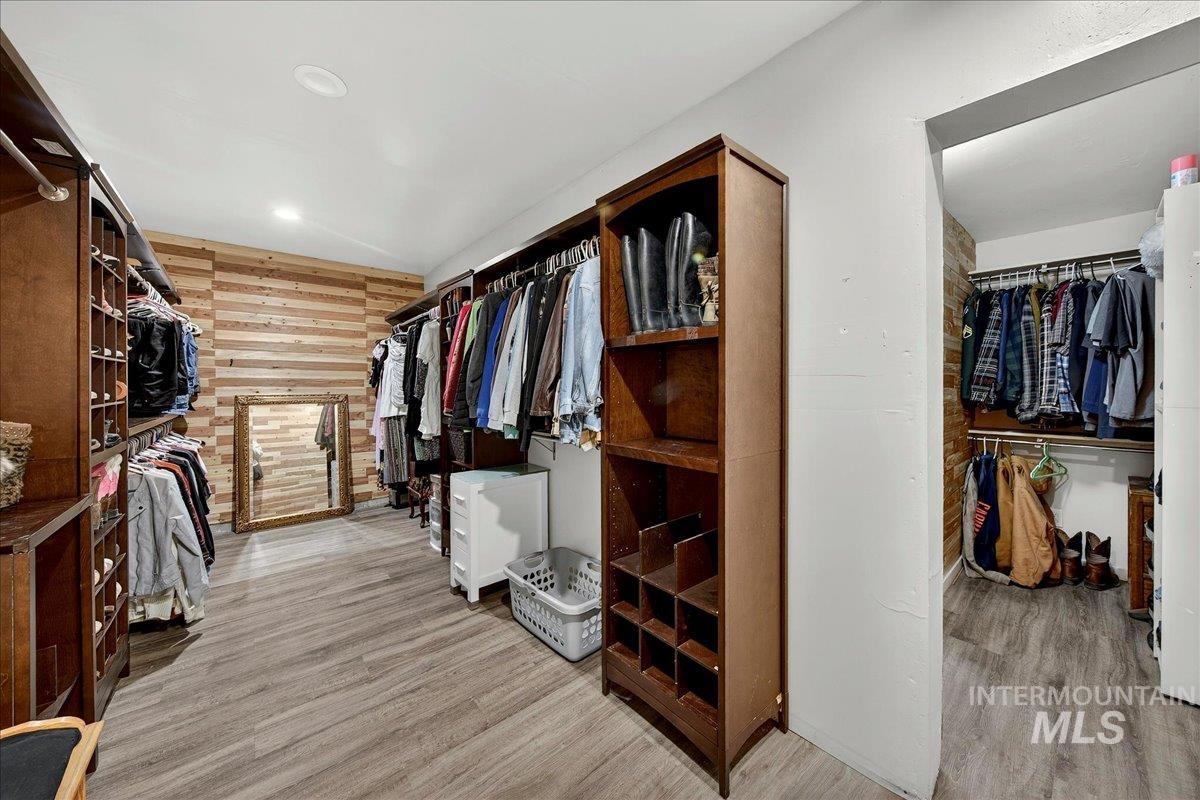 Walk in closet with light wood-style floors